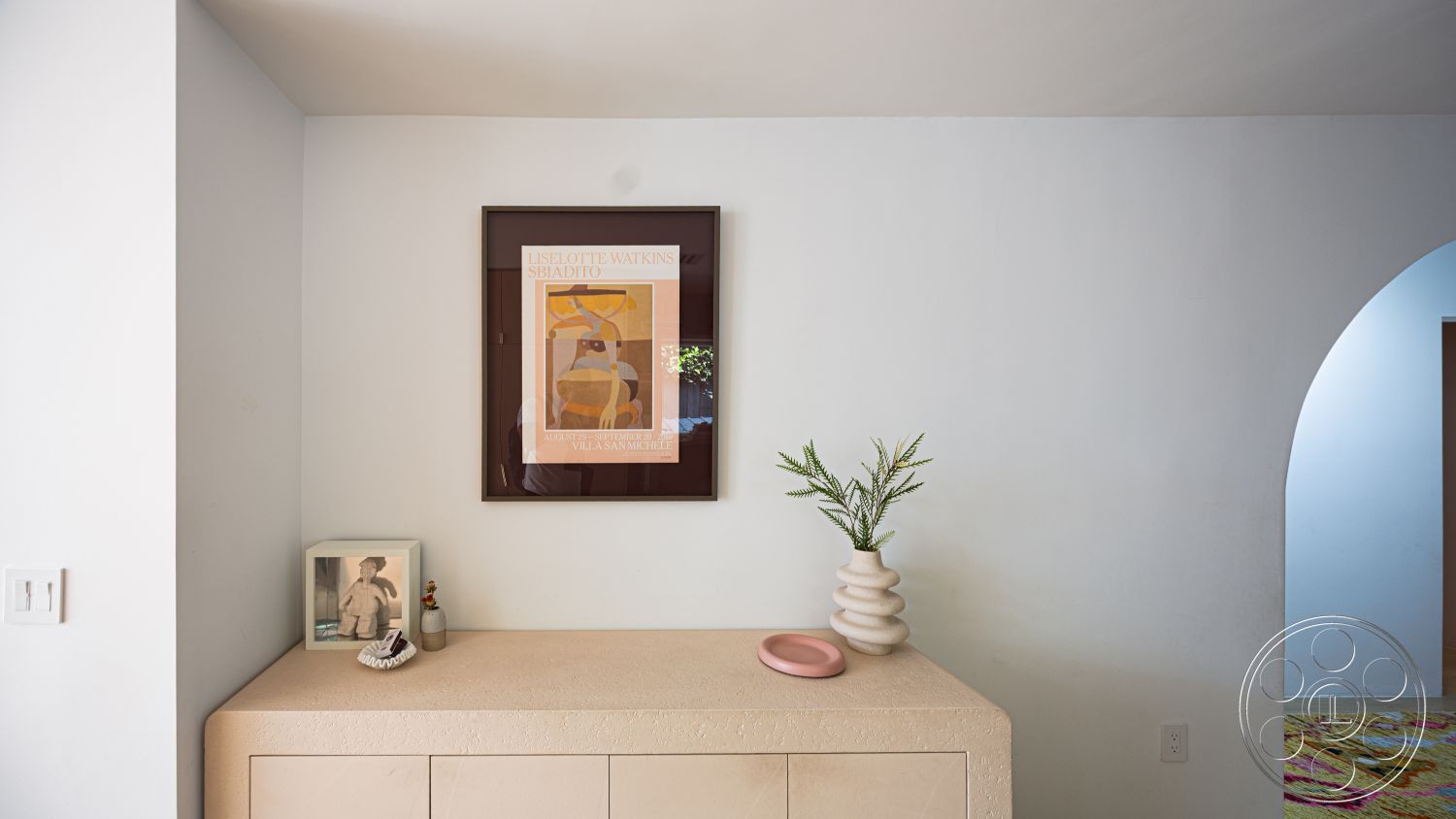 Modern 519 - interior minimalist decor, interior white painted walls, interior light wood cabinetry, interior arched doorway, interior textured plaster wall treatment, interior natural stone tabletop, interior round ceramic vase, interior decorative art frame, interior angled corner countertop, interior framed photographs display, interior soft textile rug, interior ambient natural light