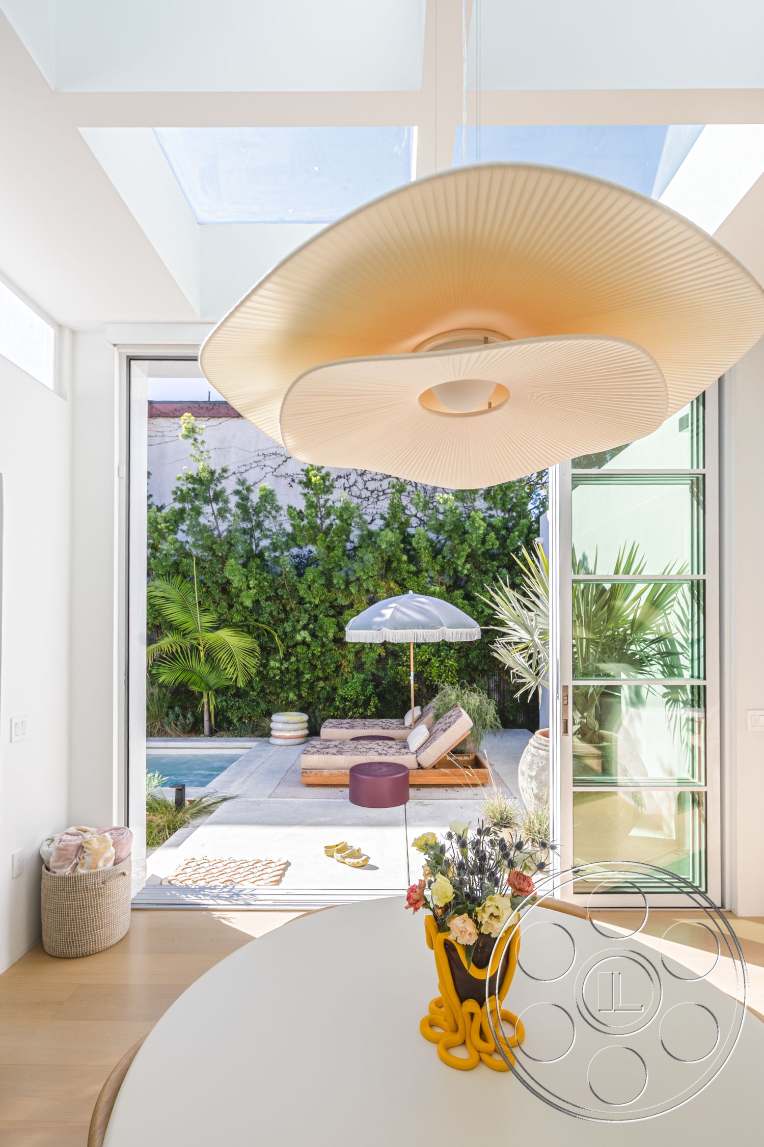 Modern 519 - rectangular pool, outdoor lounge area, concrete patio flooring, sunshade umbrella, white painted walls, modern minimalist design, open-concept living space, floor-to-ceiling glass doors, hardwood dining room floors, tropical plant decor, curved ceiling light fixture, decorative flower vase, light-filled room