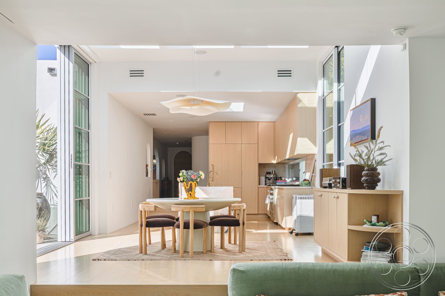 Modern 519 - interior recessed lighting, interior modern pendant lighting, interior natural light, interior minimalist decor, interior floor-to-ceiling windows, interior open concept layout, interior natural fiber area rug, interior built-in kitchen cabinets, interior spacious living area, interior round dining table, interior hardwood dining room floors, interior seamless indoor-outdoor flow, interior light wood cabinetry, interior greenery accents, interior white plaster walls, interior soft green sofa, interior contemporary art wall