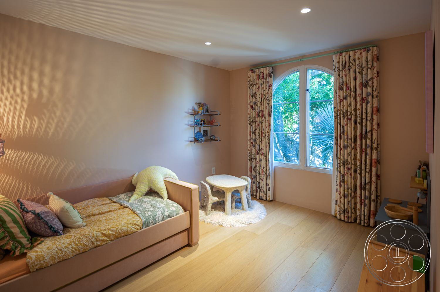 Modern 519 - cozy atmosphere, textured throw pillows, soft area rug, floral patterned curtains, playful design elements, child-friendly decor, decorative wall shelves, hardwood bedroom floors, minimalist furniture arrangement, arched window design, pink painted walls, light fixture with soft glow, small wood accent table, sunlight streaming through window