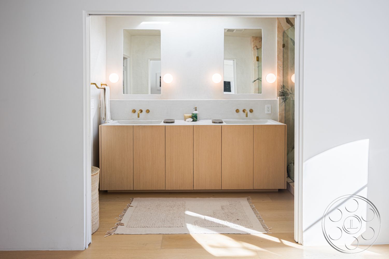 Modern 519 - quartz countertop, neutral color palette, natural light, minimalist design, open layout, light wood flooring, double sink vanity, wall-mounted lighting, textured plaster walls, rectangular mirrors, woven rug, oak cabinetry, gold faucet fixtures, interior bathroom, framed shower glass