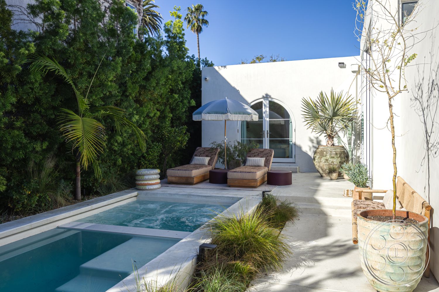 Modern 519 - natural light, exterior, modern architecture, minimalist design, potted plants, outdoor seating area, landscape design, tropical landscaping, arched windows, luxury outdoor space, rectangular pool, canopy umbrella, textured plaster wall, concrete pool border, concrete patio floor, paved garden path, exposed wood lounge chairs, wrapped palm trees, finished concrete steps, cozy patio seating