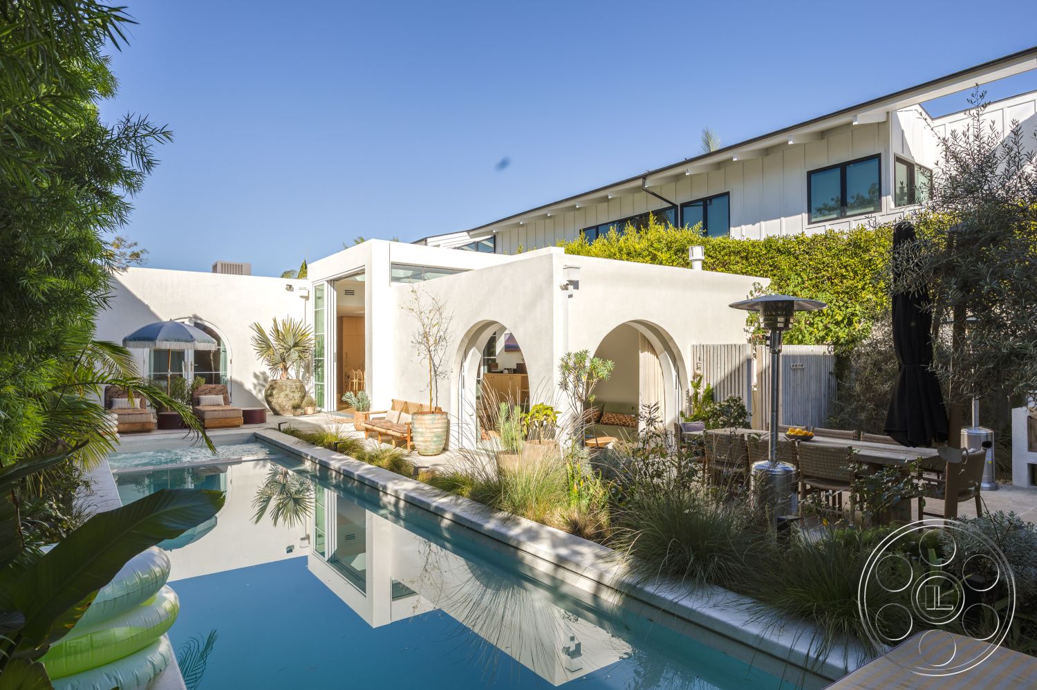 Modern 519 - white stucco walls, glass sliding doors, modern landscaping, rectangular swimming pool, floor-to-ceiling windows, paved stone patio, wooden outdoor furniture, concrete pool border, interior lounge area, urban garden oasis, exterior pool area, flat roof architecture, luxury residential setting, open patio design, arcade garden arches, framed by lush greenery, hardscaped garden layout, multi-level sun deck, contemporary outdoor heating lamps