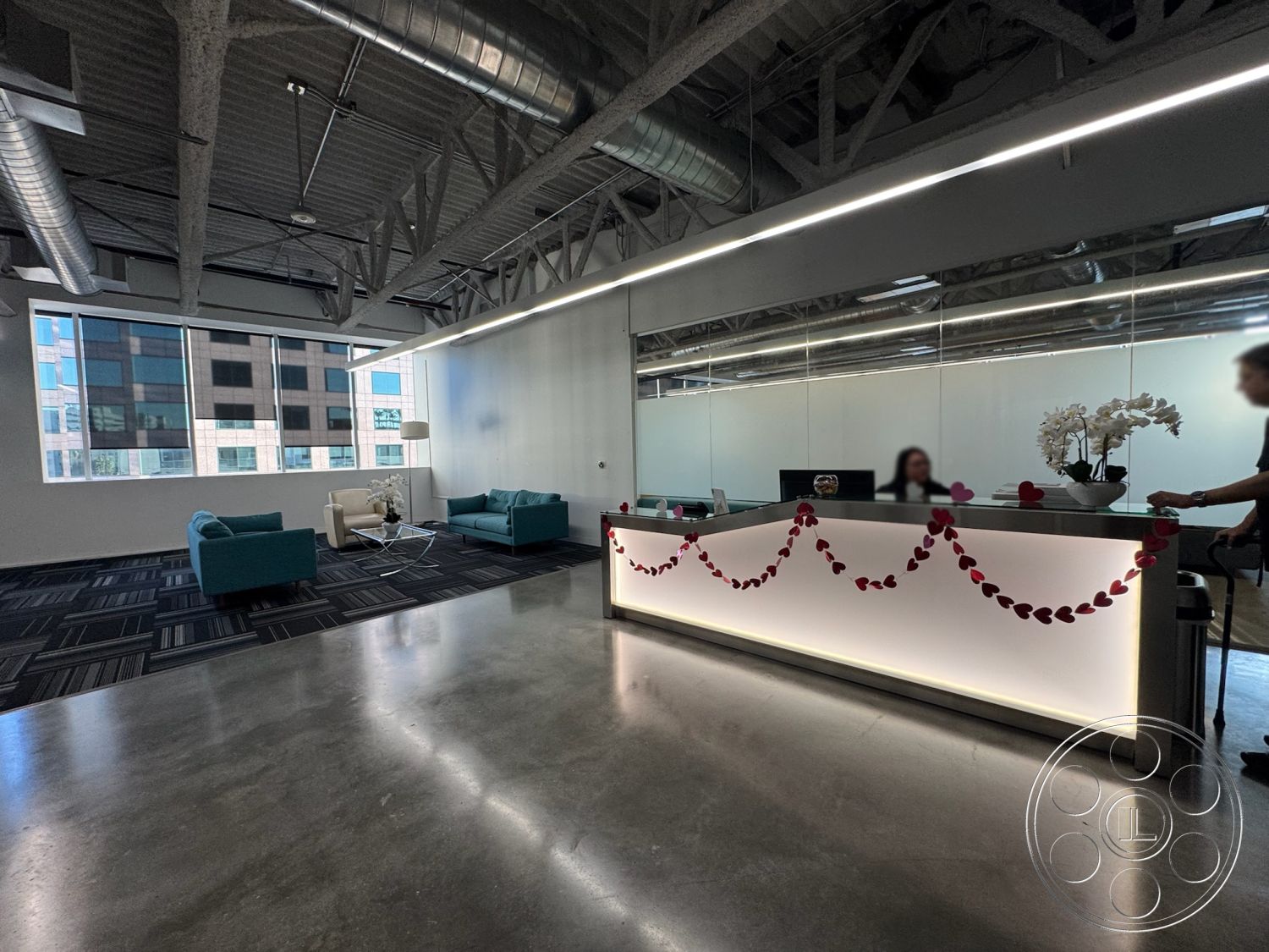 Office 128 - minimalist decor, contemporary style, floor-to-ceiling windows, square coffee table, comfortable lounge area, open floor plan interior, urban office setting, modern reception desk, glass partition wall, striped carpet tiles, brightly lit workspace, metal ceiling beams, exposed concrete floors, LED accent lighting, tufted upholstered seating, reflected lighting from mirrors, potted orchid decor