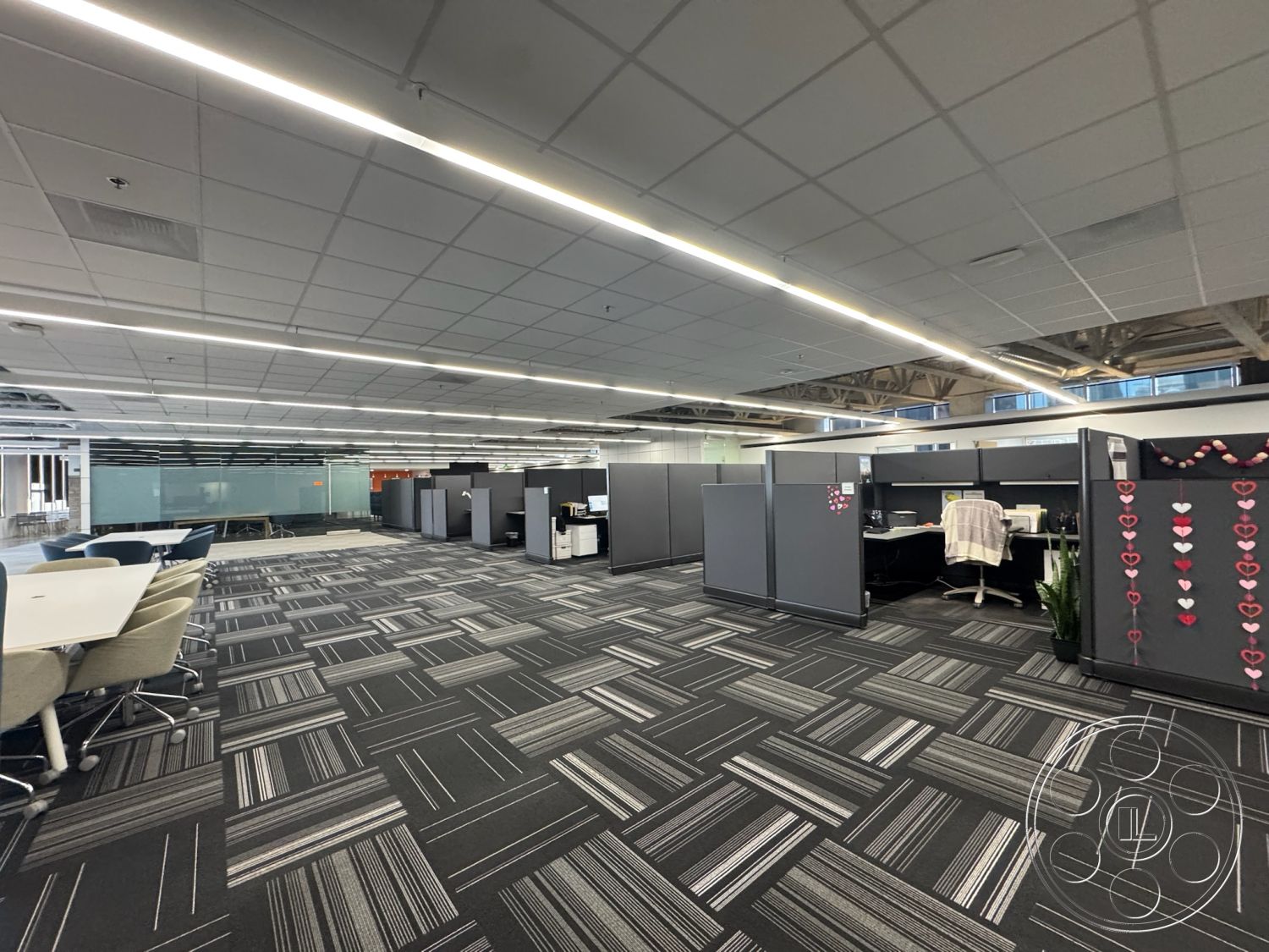 Office 128 - neutral color palette, modern aesthetic, gray carpet flooring, ergonomic office chairs, acoustic ceiling tiles, glass partition walls, interior open office space, urban office setting, open workspace layout, suspended LED lighting, modular office cubicles, shared conference tables, collaborative office environment, accessible power outlets, creative workspace design, flexible office seating