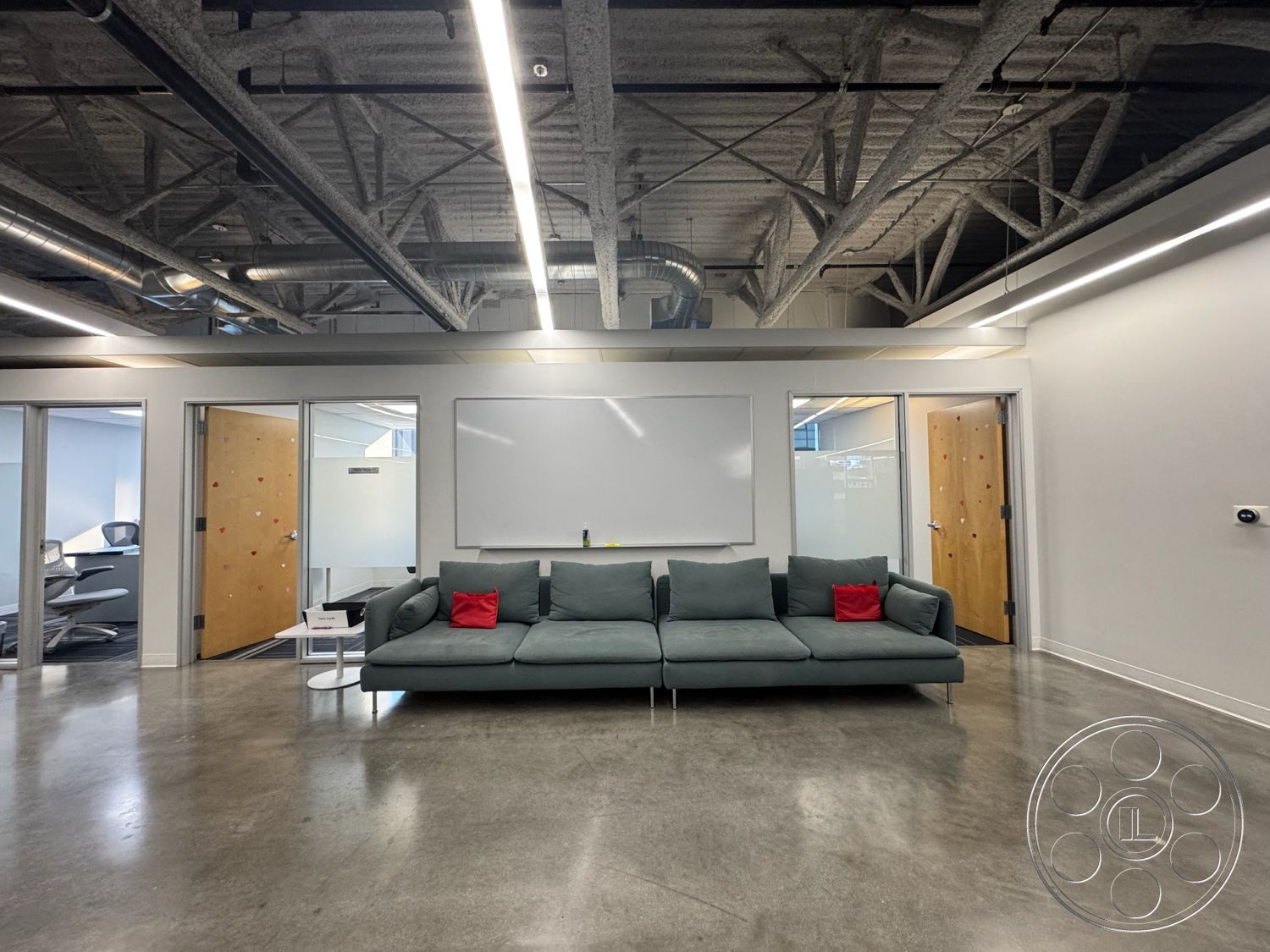 Office 128 - neutral color palette, open concept layout, industrial style, minimalist coffee table, exposed steel beams, brightly lit space, comfortable lounge area, glass partition walls, modern sectional sofa, interior office space, track lighting fixtures, whiteboard wall, creative workspace environment, concrete polished flooring, wooden door with peep holes