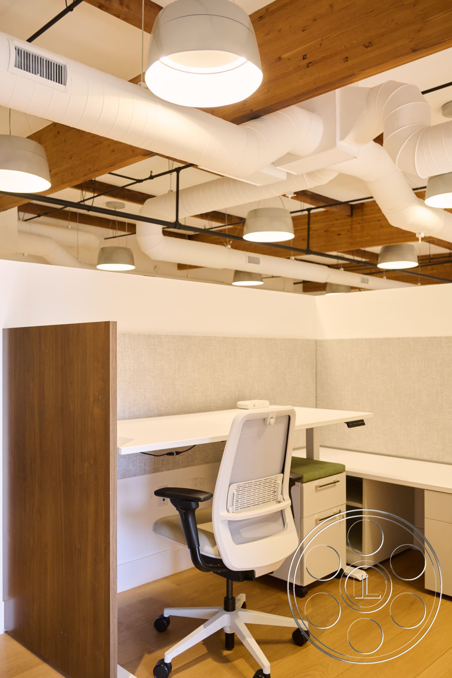 Office 129 - neutral color palette, hardwood flooring, creative office environment, semi-open layout, ergonomic office chair, exposed wood ceiling beams, white painted walls, interior office space, functional workspace design, industrial ductwork, gray fabric wall panels, modern workstation, built-in desk with storage, minimalist office lighting, suspended pendant lights