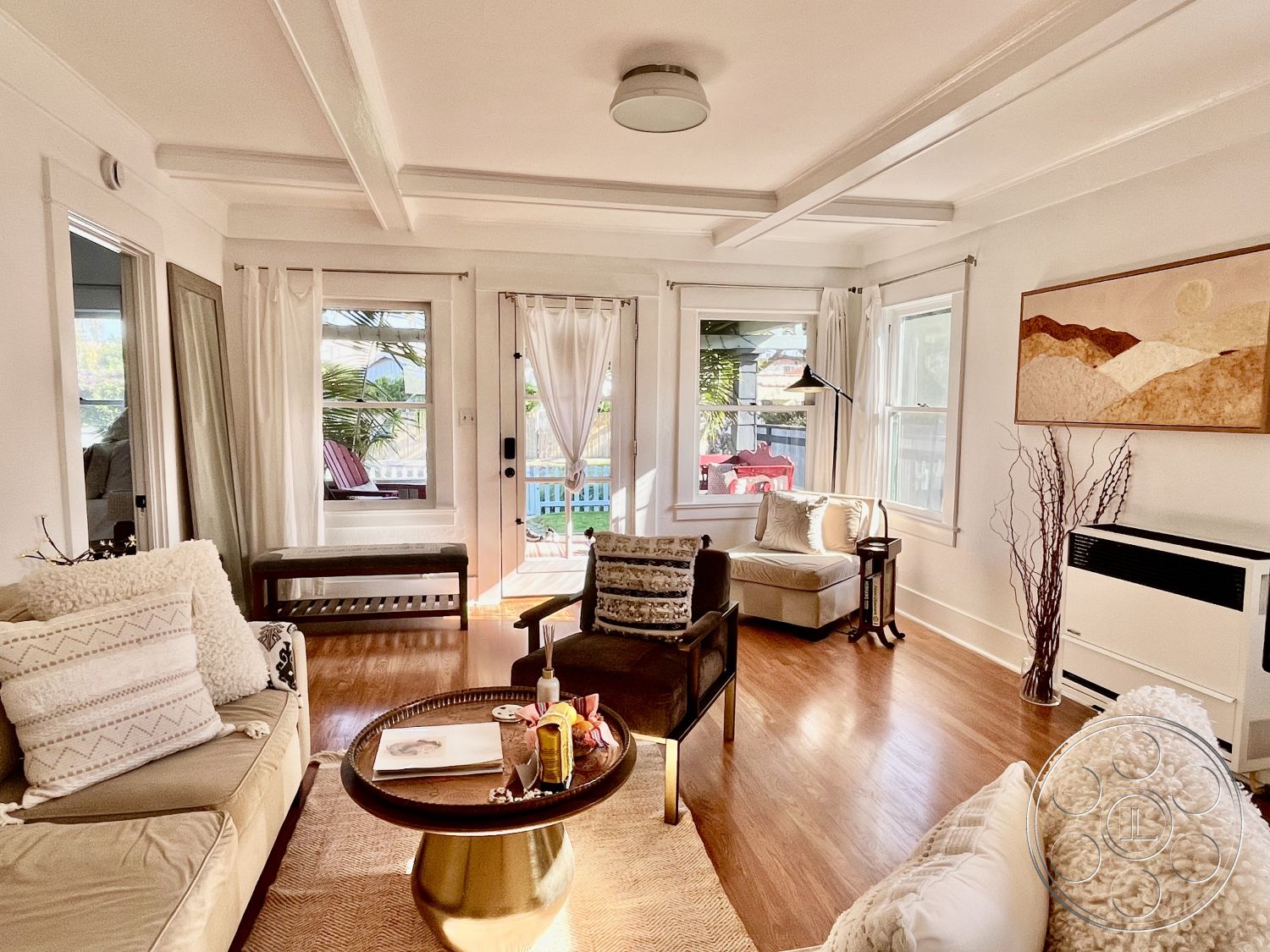 Craftsman 56 - neutral color palette, textured area rug, cozy seating arrangement, open-concept layout, modern floor lamp, exposed wood ceiling beams, hardwood living room floors, white painted walls, interior natural light ambiance, indoor plant accents, large windows with sheer curtains, inviting home atmosphere, round coffee table with decorative items, beige sectional sofa with patterned cushions, contemporary armchair with metal legs, framed wall art with abstract design, wooden bench with slatted design