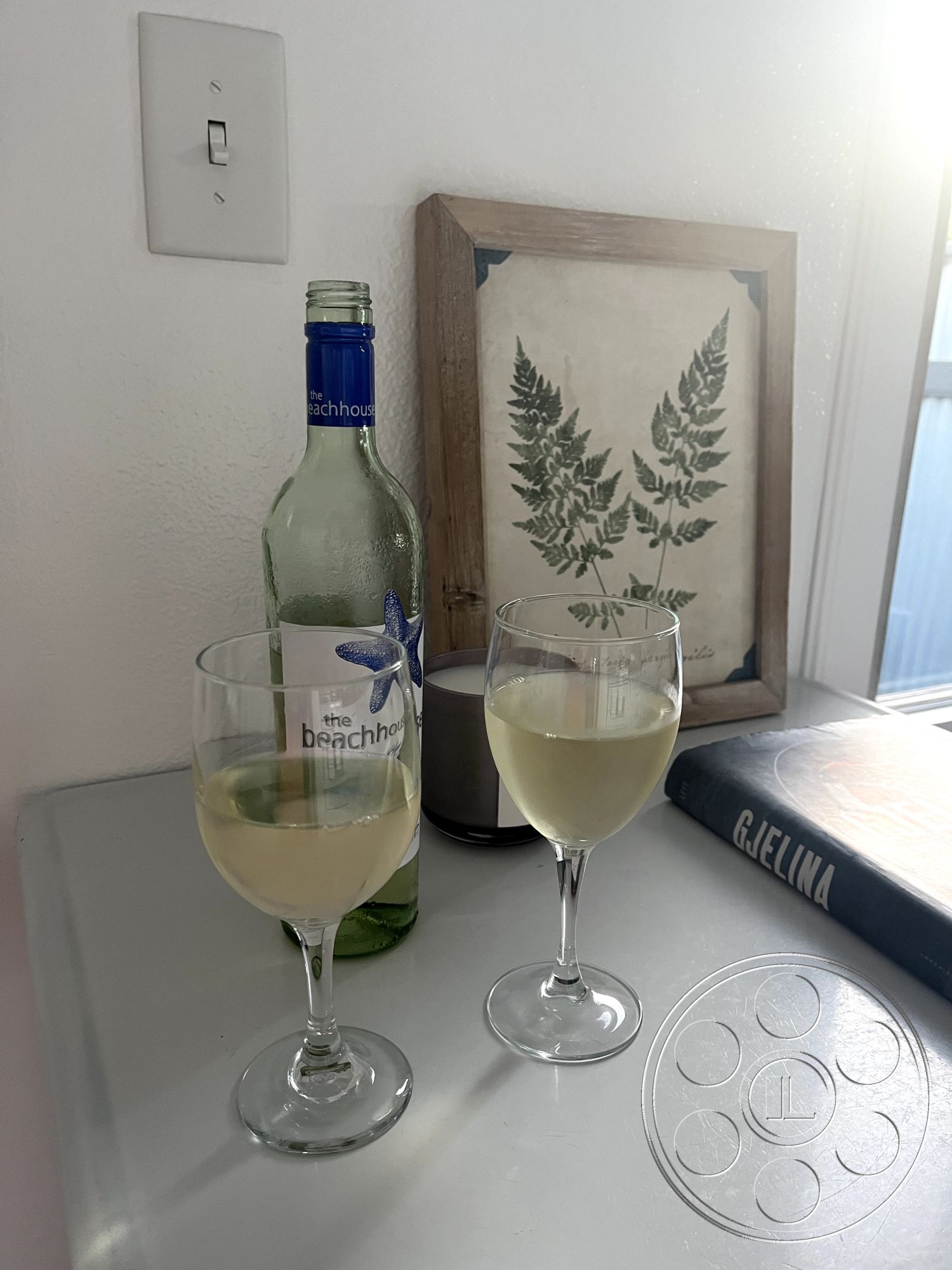 Craftsman 56 - neutral color palette, casual dining space, contemporary aesthetic, glass wine glasses, minimalist interior design, natural light ambiance, open concept interior, white painted interior walls, framed botanical art, metal light switch, kitchen countertop, beach house decor, cozy wine corner, suburban kitchen setting