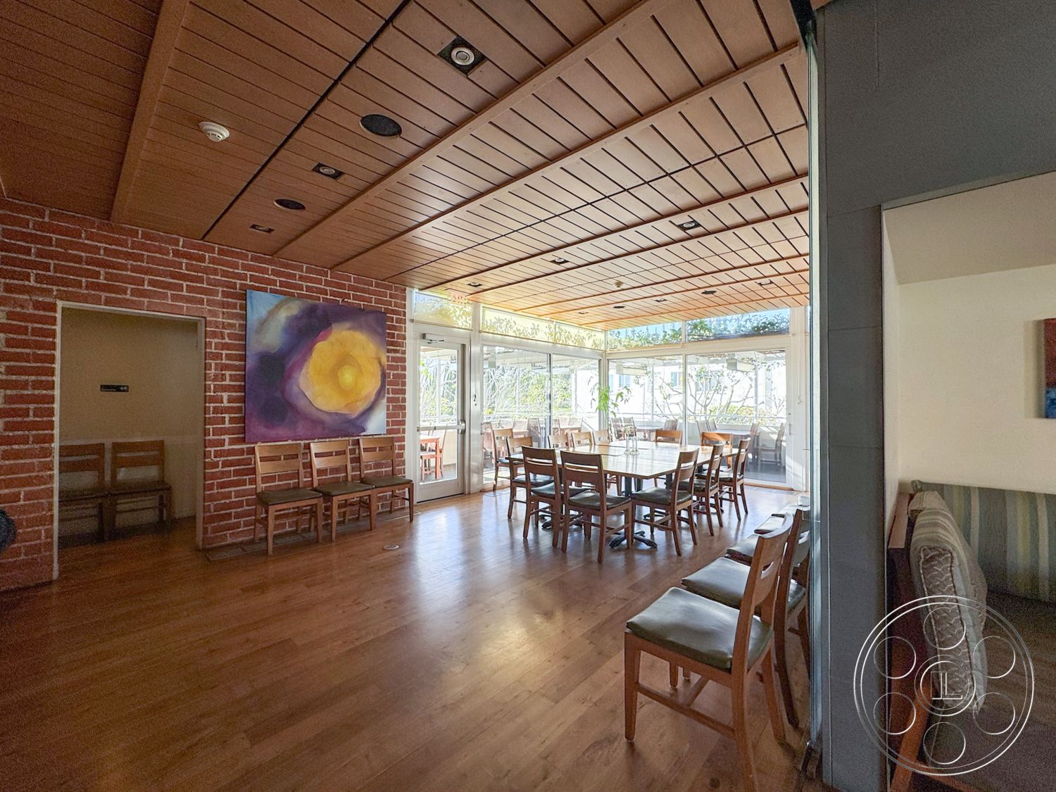 Adams Mansion - glass sliding doors, natural light from large windows, casual dining atmosphere, modern dining area, minimalist decor elements, exposed brick accent wall, open concept interior, hardwood dining room floors, colorful abstract wall art, wooden ceiling panels, rectangular dining room table, unfurnished seating area, indoor plants in bright room, restaurant dining space