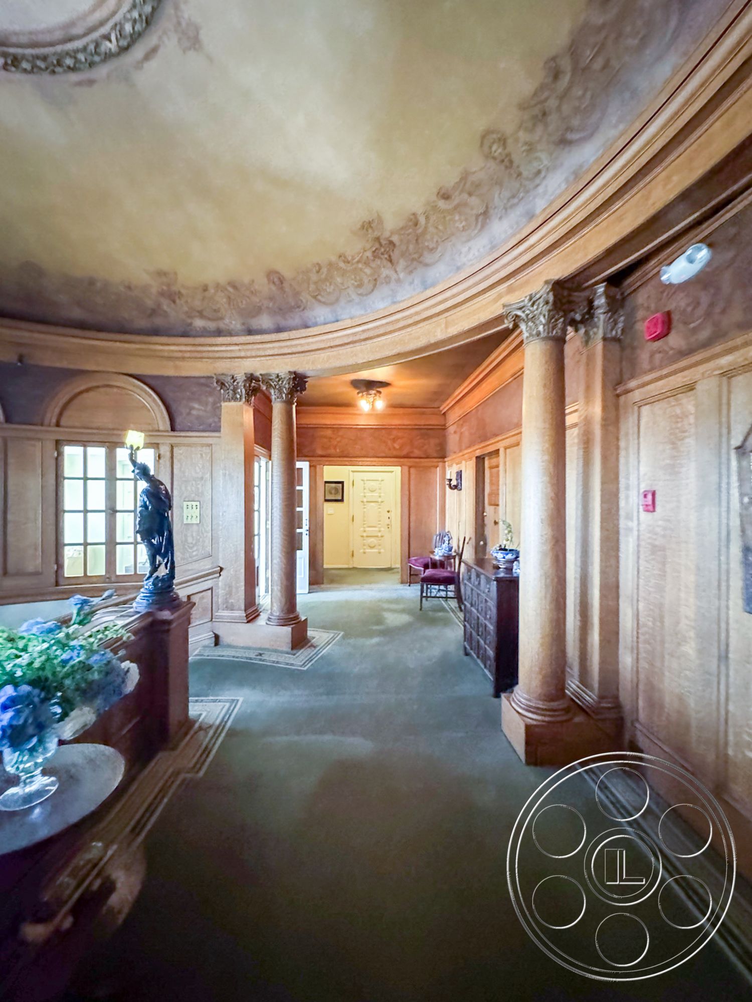 Adams Mansion - exterior, built-in shelving, arched doorways, arched windows, traditional wall sconces, vintage accent chair, columned entryway, wood paneling walls, potted floral arrangements, intricate molding details, carpet hallway flooring, ornate ceiling design, round ceiling with decorative plaster, classic foyer design, stately wooden front door, statue accent decor, transom window above door