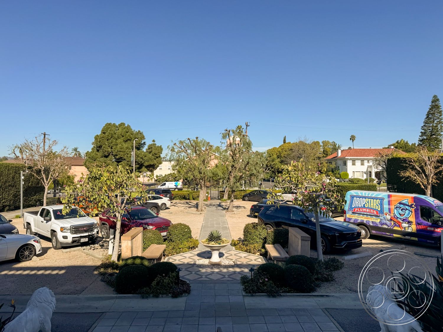 Adams Mansion - exterior, paved pathway, gravel driveway, ornamental trees, formal garden setting, planted flower beds, decorative stone border, urban residential neighborhood, open sky view, concrete wall planters, concrete entry steps, vehicle parking area, landscape shrubs, brick sidewalk, well-maintained lawns, stone garden benches