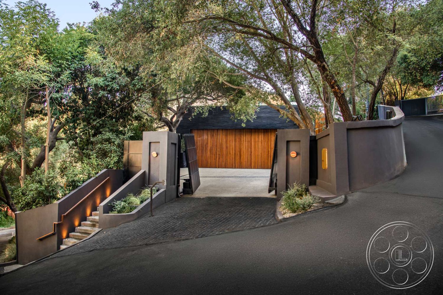 Modern 520 - landscaped garden, natural stone accents, minimalist design, lush greenery, metal railings, textured wall finish, surrounding trees, modern architectural style, concrete driveway, wooden garage door, curved wall design, cobblestone pathway, asphalt road, elevated entrance, hilltop location, exposed aggregate concrete steps, sleek contemporary architecture, exterior entrance gate, built-in outdoor lighting