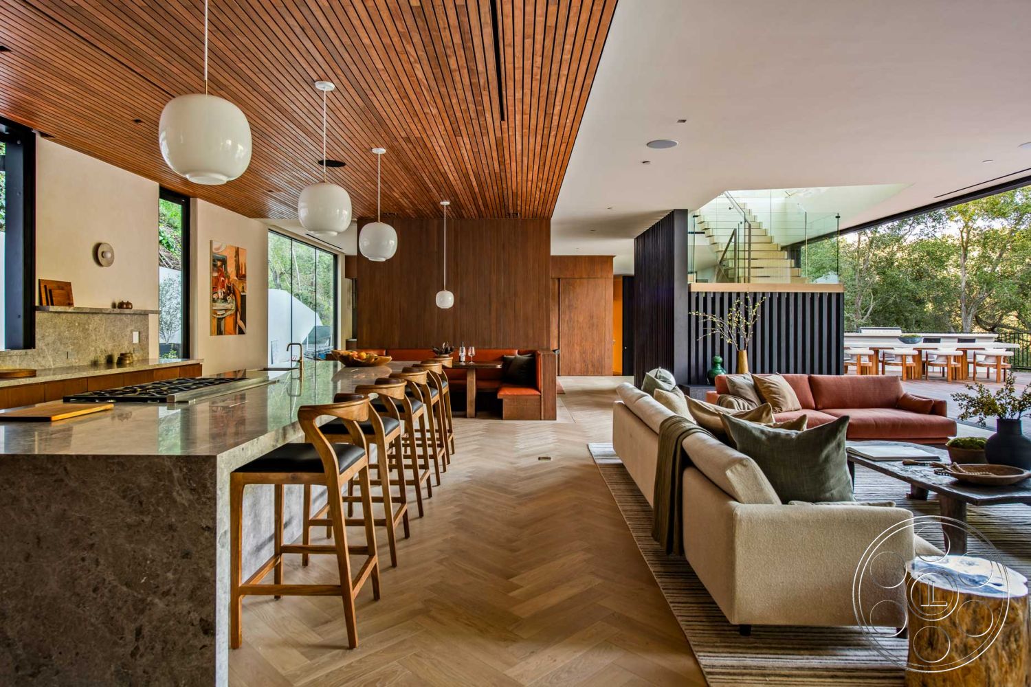 Modern 520 - interior neutral color palette, interior contemporary kitchen design, interior modern cabinetry, interior pendant lighting fixtures, interior wood beam ceiling, interior marble kitchen island, exterior glass sliding doors, interior hardwood herringbone flooring, interior decorative wall art, interior exposed wood accent wall, interior black-framed windows, interior built-in wooden seating, interior open floor plan kitchen and living area, interior stone countertop, exterior expansive outdoor dining area, interior textured fabric sofa, exterior lush green landscaping