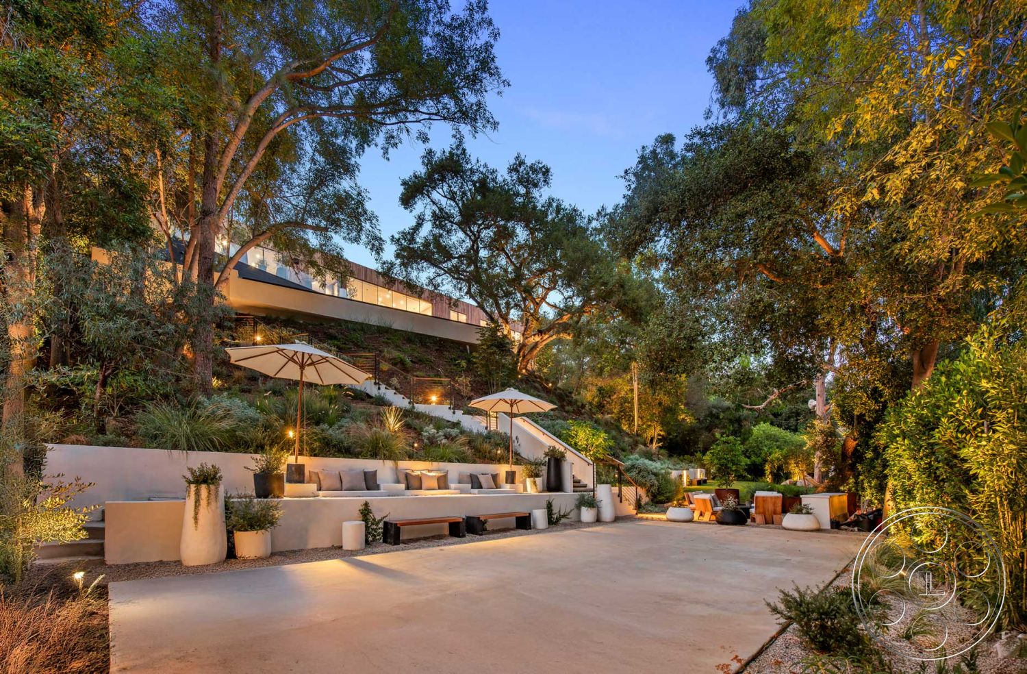 Modern 520 - outdoor lounge area, contemporary architectural style, exterior concrete patio floor, surrounding forest setting, exterior concrete walls, curved garden pathways, exterior hillside location, exterior minimalist design elements, exposed aggregate driveway, exterior natural stone steps, exterior wood beam accents, outdoor shaded seating area with umbrellas, landscaped garden patio with native plants, exterior modern home with floor-to-ceiling windows, outdoor living space with natural wood furniture, exterior lighting fixtures highlighting landscape, natural stone planter beds, exterior terraced garden design, informal outdoor dining area, decorative gravel pathways