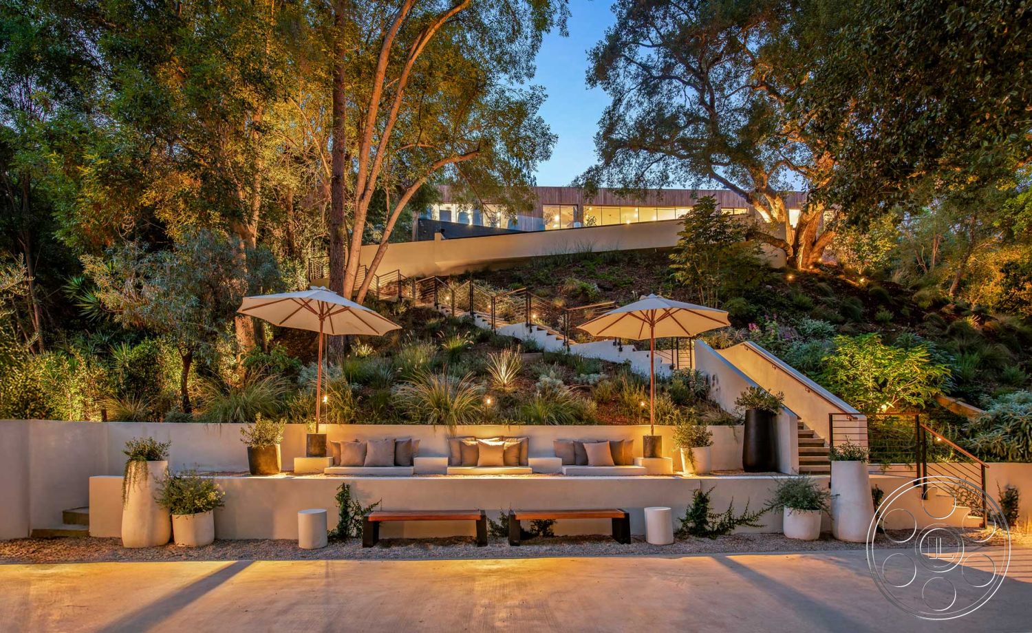 Modern 520 - wooden bench seating, contemporary outdoor lighting, concrete patio floor, interior mountain view, lush landscaped garden, exposed aggregate concrete steps, modern railing design, curved patio layout, exterior greenery backdrop, concrete outdoor seating area, metal umbrella stands, textured stone garden walls