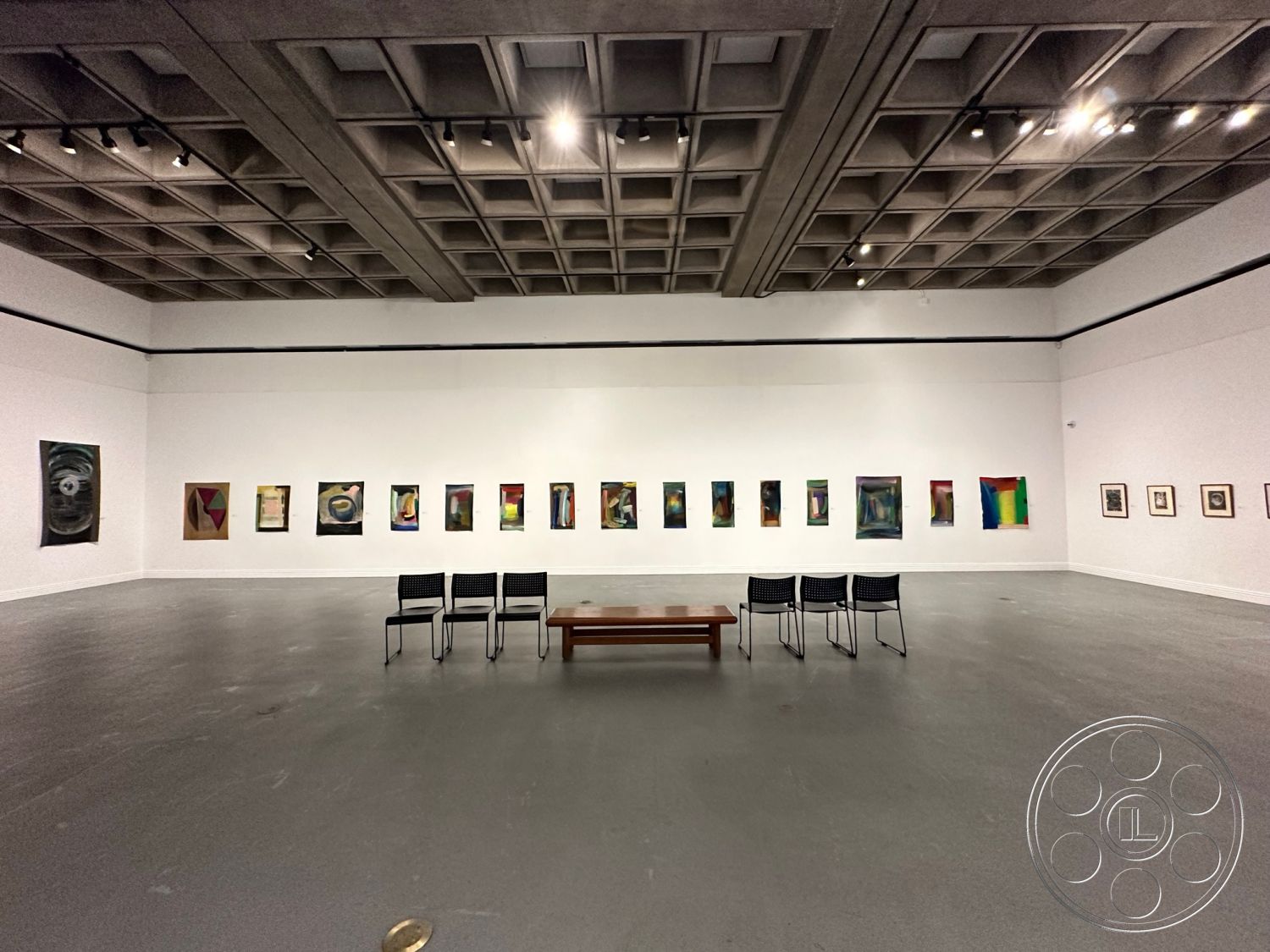 Art Gallery DTLA - neutral color palette, wooden coffee table, open floor plan, polished concrete flooring, white painted walls, minimalist architectural design, rectangular seating arrangement, industrial style elements, exposed concrete ceilings, gallery space interior, suspended track lighting, art exhibit wall display, geometric art installations, contemporary art gallery