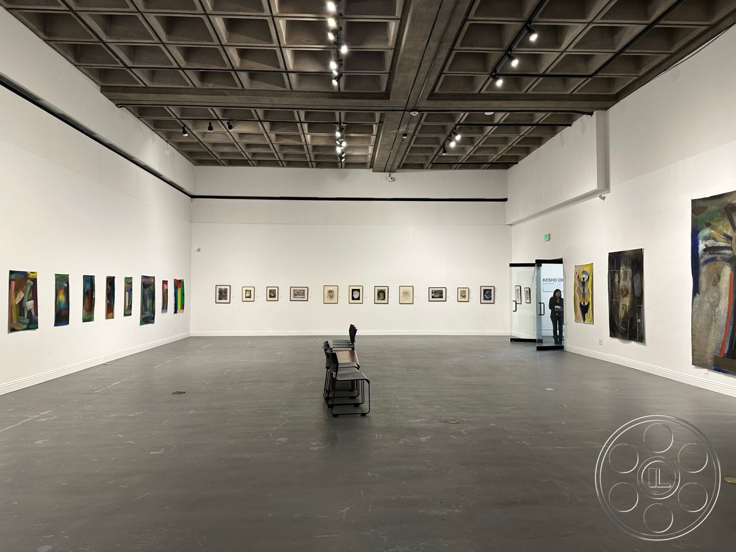 Art Gallery DTLA - open floor plan, exposed concrete ceiling, museum-like atmosphere, minimalist design aesthetic, track lighting fixtures, plastered wall treatments, epoxy resin flooring, rectangular art display layout, white painted gallery walls, modern gallery space, interior art exhibition area, gallery seating benches, geometric ceiling panels, commercial gallery space, brightly lit exhibition hall, curated art presentation, black framed artwork displays