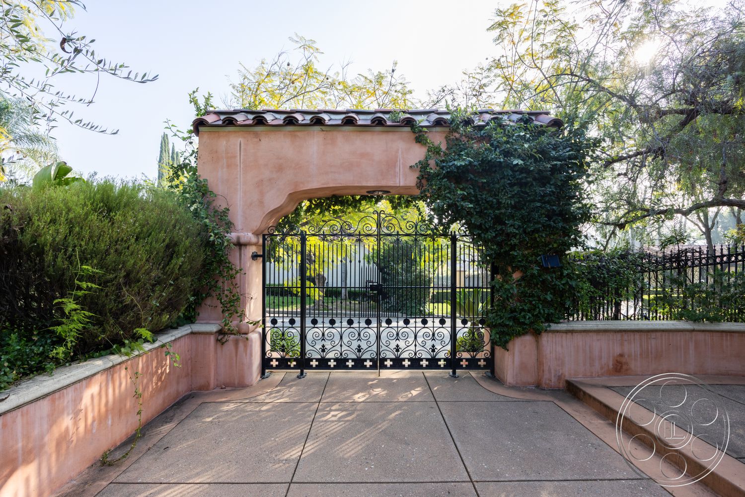 Mansion 145 - exterior, paved driveway, outdoor access, soft natural lighting, arched entryway, tile roof, stucco wall, planted landscaping, flagstone pathway, courtyard entryway, tropical garden setting, decorative wrought iron gate, rustic architectural details, cozy outdoor atmosphere, ornamental vines, earth-toned exterior finish