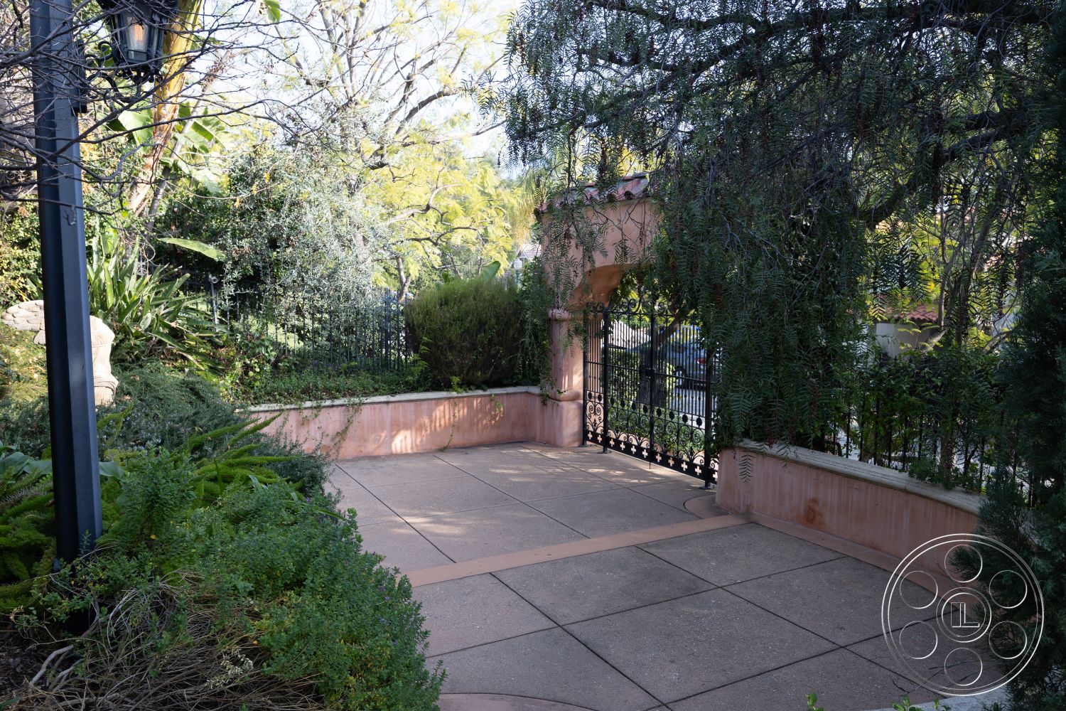 Mansion 145 - landscaped garden setting, surrounding lush greenery, curved patio design, natural light ambiance, exterior patio flooring, potted greenery accents, suburban backyard retreat, stamped concrete patio surface, plastered garden wall, ornate wrought iron gate, textured concrete border, enclosed outdoor area, soft landscaping details, light-filtering overhead canopy, decorative stone feature wall