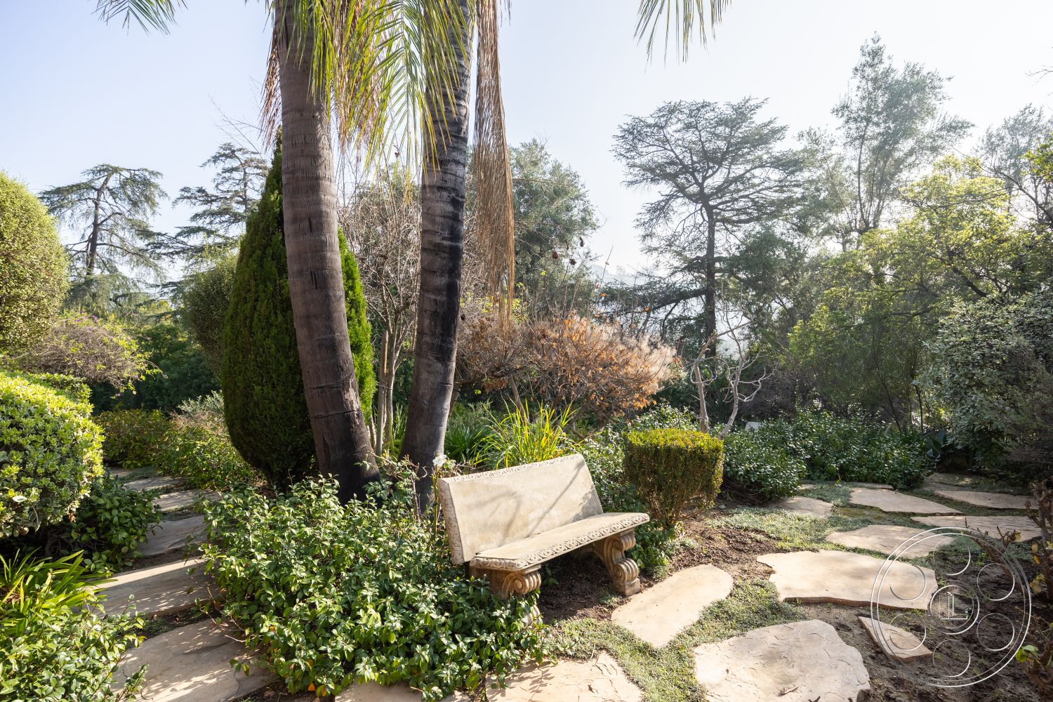 Mansion 145 - palm trees, natural stone pathway, flagstone walkway, lush green foliage, sunlit garden area, seasonal flowering plants, tropical garden setting, urban backyard oasis, exterior garden seating, landscape shrubs and hedges, tropical landscaping style