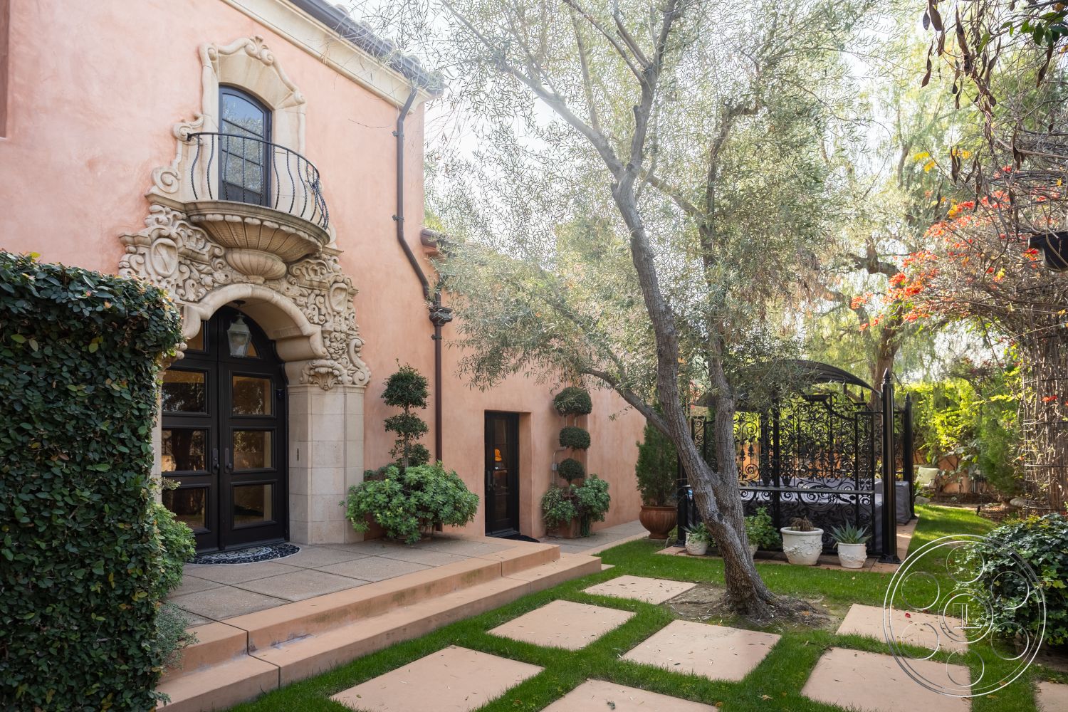 Mansion 145 - outdoor seating area, lush green lawn, wooden pergola, tile roof, paved stone patio, Mediterranean architectural style, flagstone pathway, topiary hedges, landscaped garden area, exterior stucco walls, textured stucco finish, exposed aggregate concrete, decorative planter pots, wrought iron balcony railing, lush foliage backdrop, suburban outdoor setting, concrete patio steps, ornate stone facade, gabled roof dormer window, decorative archway detailing, cobblestone walkways, garden arbor