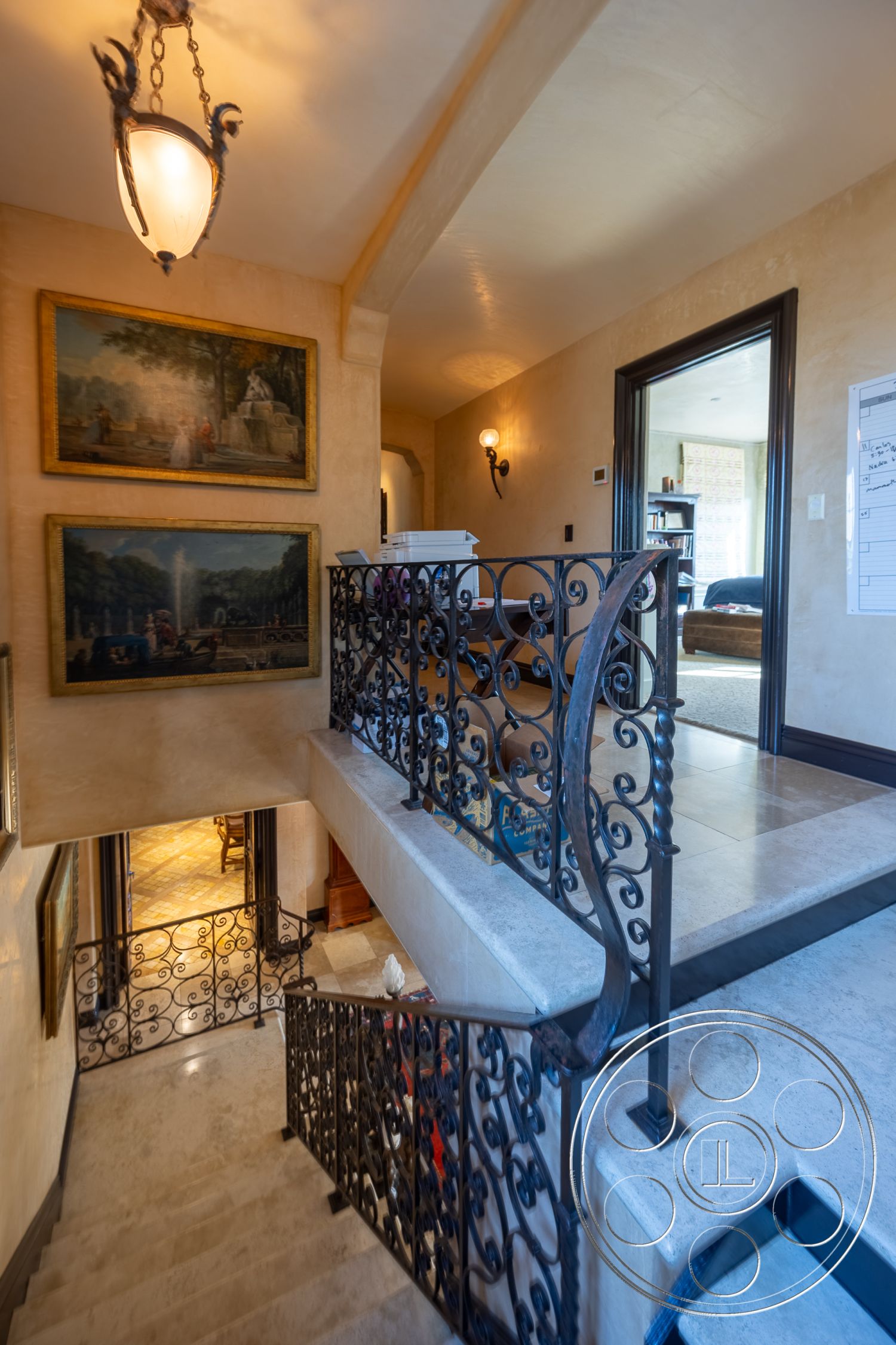 Mansion 145 - textured plaster walls interior, natural light from large windows interior, warm color palette interior, arched doorways interior, exposed stone walls interior, marble staircase flooring interior, iron spiral staircase railing interior, ornate chandelier lighting interior, framed artwork wall decor, dark wood frame door interior, timeless classic architecture, vaulted ceilings with subtle curves interior, elegant artwork accents, crafted metalwork railings interior, luxurious open layout interior