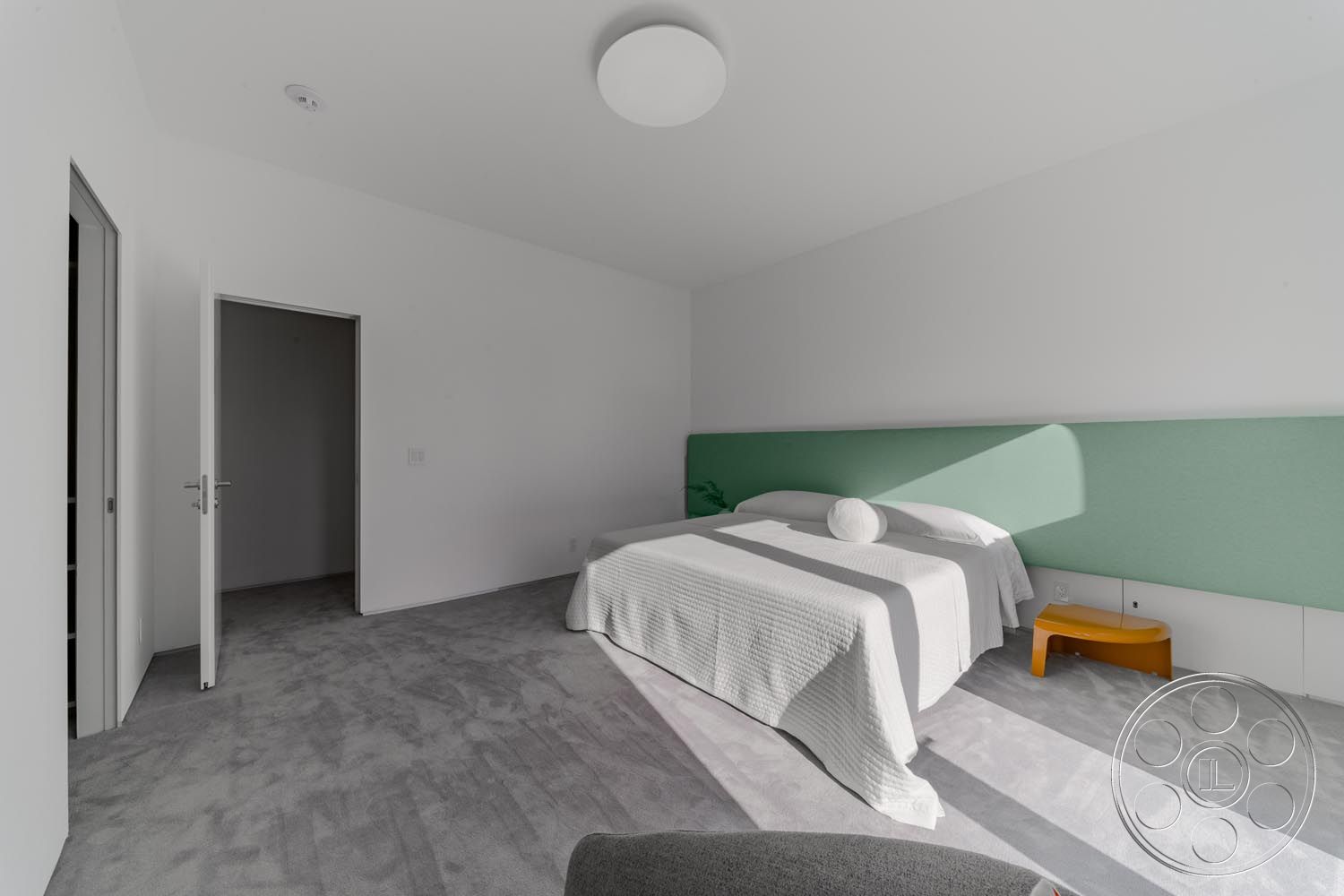 Modern 521 - neutral color palette, floor-to-ceiling windows, minimalist design details, modern minimalist aesthetic, light-filled interior, white painted walls, simple geometric forms, carpet bedroom flooring, contemporary bedroom, modern ceiling light fixture, green upholstered headboard, open door entryway, soft texture bedding, integrated bedside table, natural light accentuation