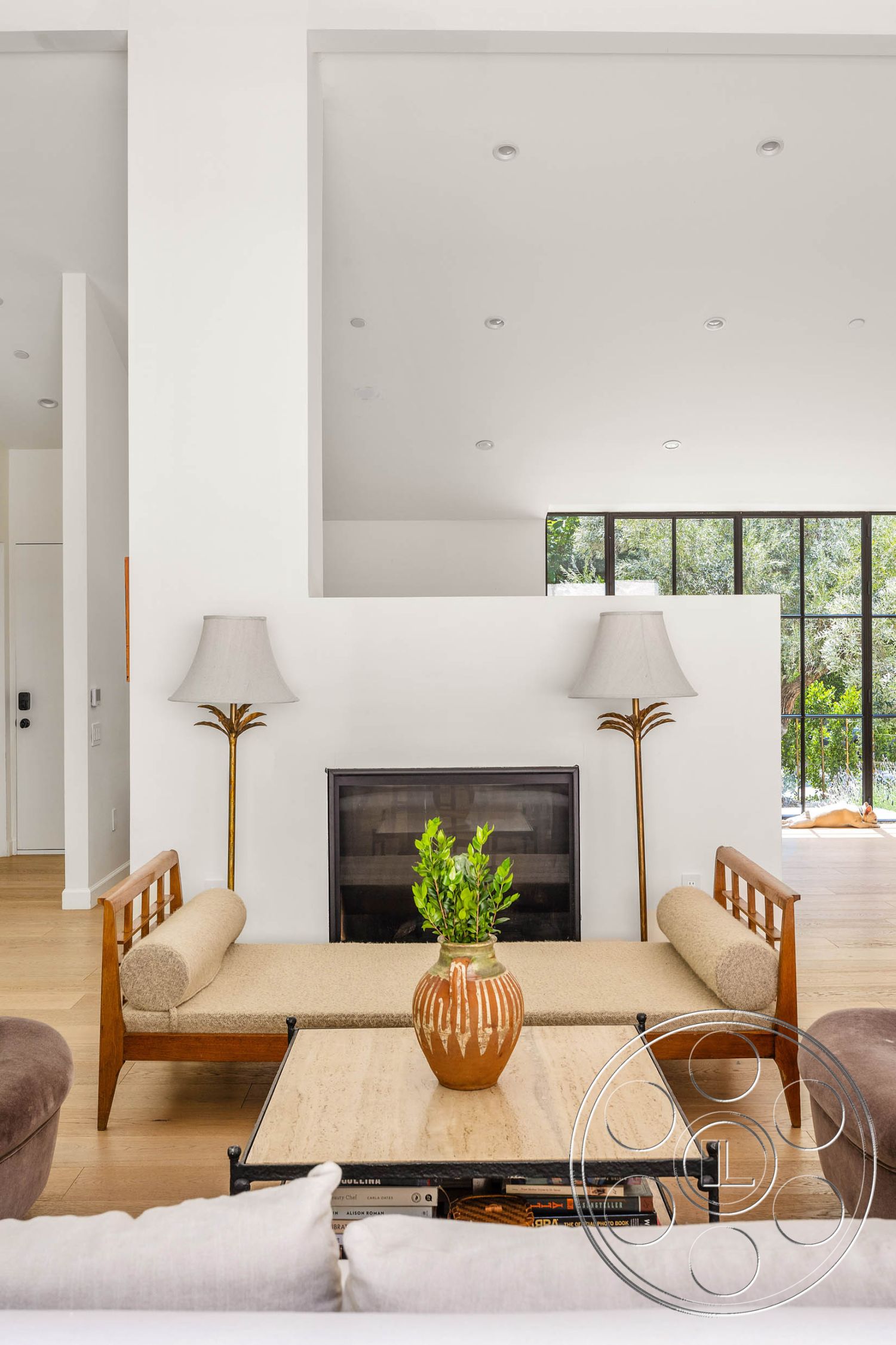 Modern Farmhouse 19 - hardwood flooring interior, neutral color palette interior, exposed wood ceiling beams interior, white painted walls interior, floor-to-ceiling windows interior, contemporary coffee table interior, minimalist living room design interior, modern fireplace wall interior, metal table legs interior, simple ceramic vase with greenery interior, decorative lamp with gold accents interior, light-filled space interior, soft seating furniture interior, open layout living area interior, elegant modern light fixtures interior