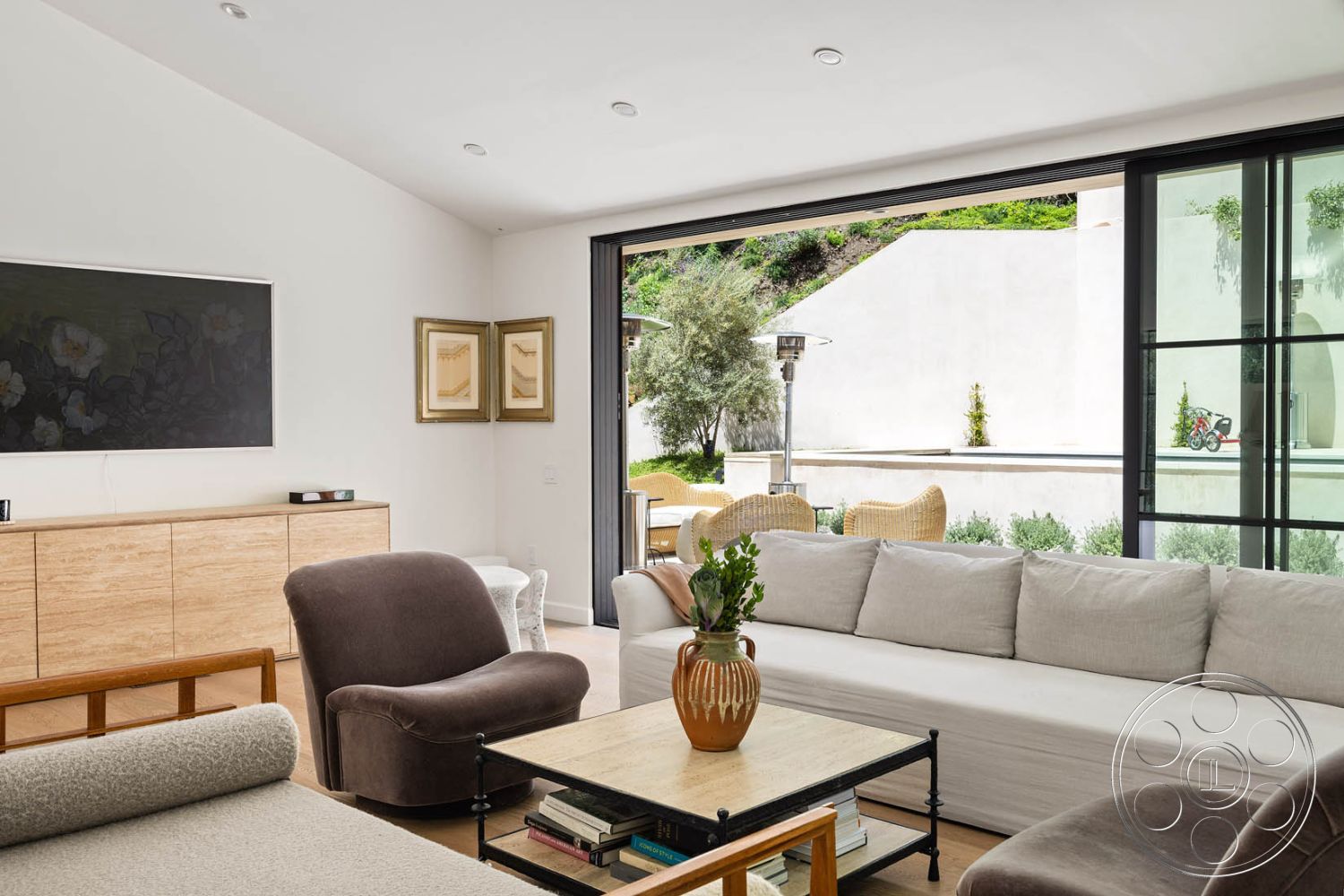 Modern Farmhouse 19 - interior, white painted walls, light hardwood flooring, modern living room furniture, minimalist design, interior, floor-to-ceiling windows, open floor plan, natural light, contemporary home, interior, beige fabric sofa, wooden coffee table, casual seating area, accent decor, interior, textured wall art, framed paintings, artistic decor elements, interior, stylish armchair, neutral color palette, relaxed atmosphere, exterior, landscaped garden view, outdoor dining area, lush greenery, modern architecture, interior, sleek cabinetry, wood grain cabinet finish, functional storage solutions, interior, natural materials, neutral color scheme, harmonious design elements, interior, comfortable seating arrangement, inviting social space, contemporary style