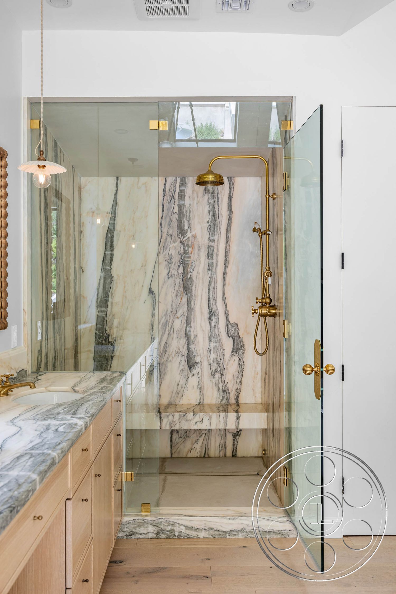 Modern Farmhouse 19 - interior recessed lighting, interior gold faucet fixtures, interior minimalist style, interior marble bathroom walls, interior marble shower walls, interior glass shower doors, interior marble shower floor, interior natural light from skylight, interior wood vanity cabinetry, interior light wood plank flooring, interior brushed gold hardware, interior modern luxury design