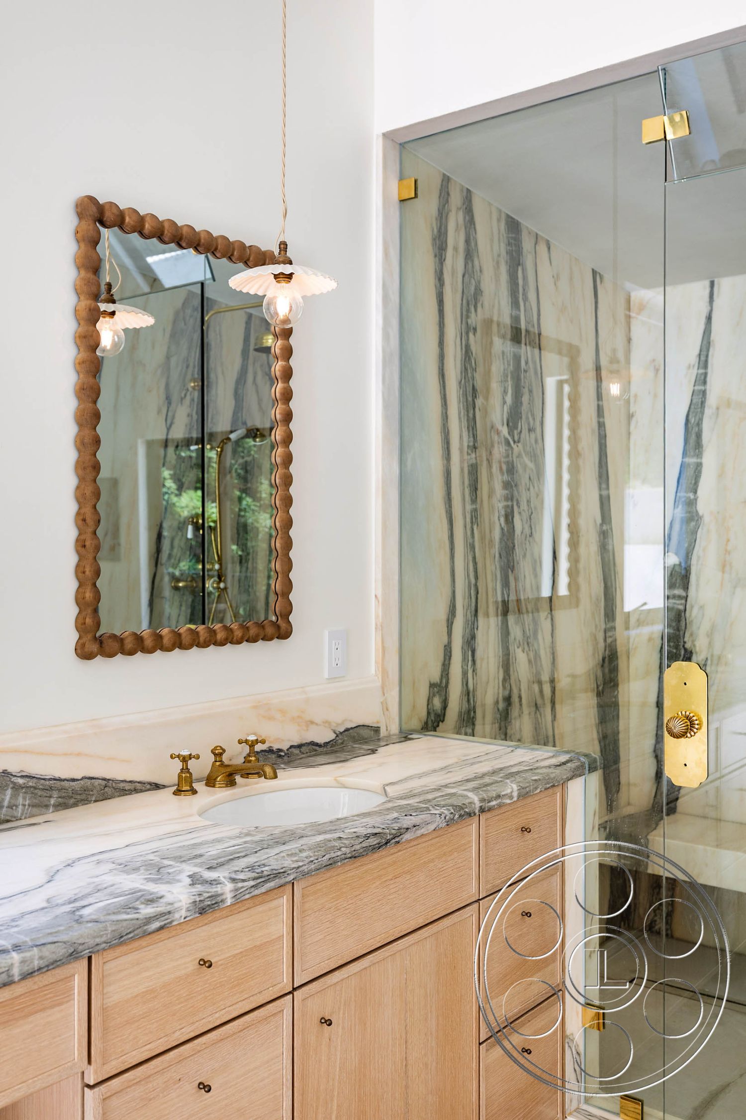 Modern Farmhouse 19 - wood cabinetry, glass shower enclosure, modern design elements, marble bathroom countertops, minimalist lighting fixture, brass faucet fixtures, textured marble wall, framed mirror with wooden border, luxurious bathroom decor