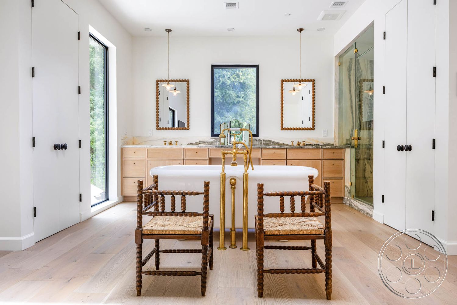 Modern Farmhouse 19 - interior hardwood flooring, interior minimalistic design, interior floor-to-ceiling windows, interior white painted walls, interior glass shower enclosure, interior decorative pendant lighting, interior marble bathroom countertop, interior contemporary style, interior custom wood cabinetry, interior woven rattan chairs, interior brushed gold fixtures, interior double vanity with mirrors, interior modern vessel bathtub, interior nature view from window