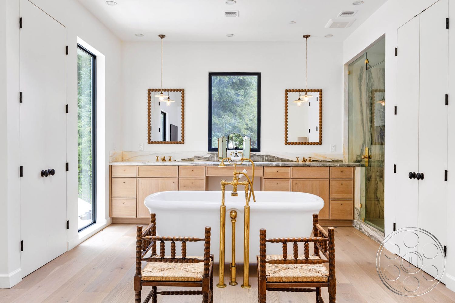 Modern Farmhouse 19 - interior recessed lighting, interior hardwood flooring, interior large windows with black frames, interior minimalistic design, interior gold faucet fixtures, interior natural light ambiance, interior glass shower enclosure, interior freestanding bathtub, interior pendant light fixtures, interior marble bathroom countertops, interior wood vanity cabinets, interior beaded mirror frames, interior closet with double doors