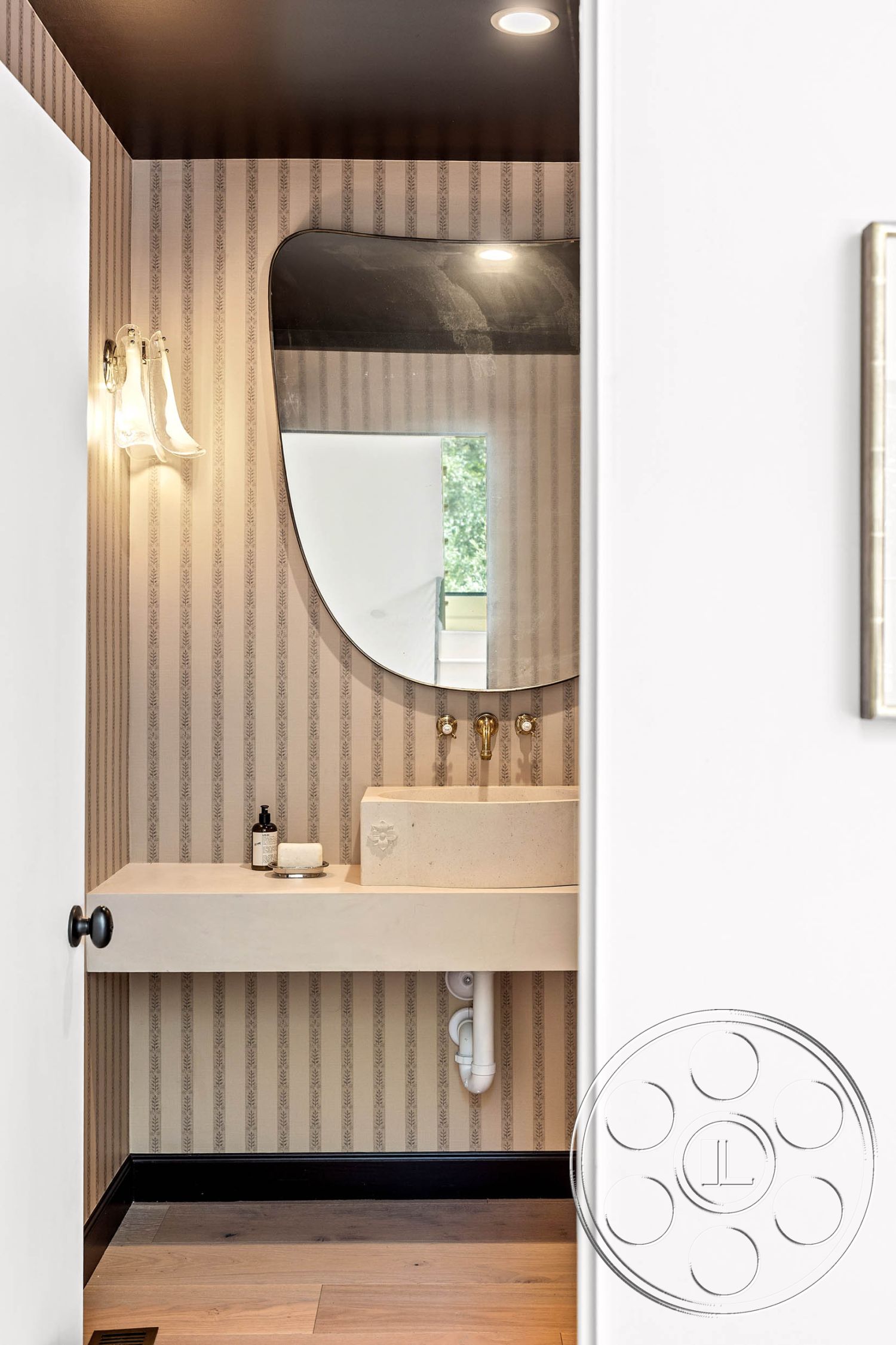 Modern Farmhouse 19 - hardwood flooring, minimalist design elements, textured plaster walls, striped wallpaper, interior bathroom space, ambient recessed lighting, brass faucet fixtures, floating concrete sink, oval shaped mirror, black trim details