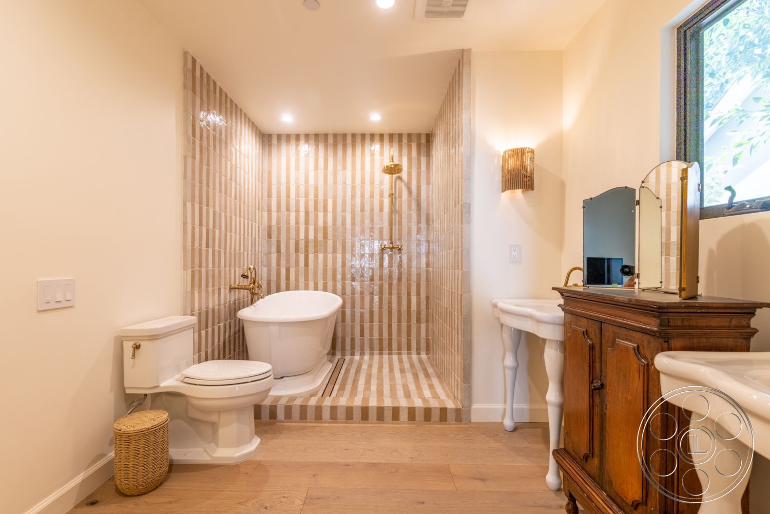 Modern Farmhouse 19 - neutral color palette, brass fixtures, decorative mirror, natural wood flooring, soft ambient lighting, natural light from window, wall-mounted sconces, interior bathroom design, floating wooden vanity, freestanding soaking tub, dual vessel sinks, minimalist bathroom layout, textured ceramic tile shower walls, striped ceramic shower tiles, traditional porcelain toilet