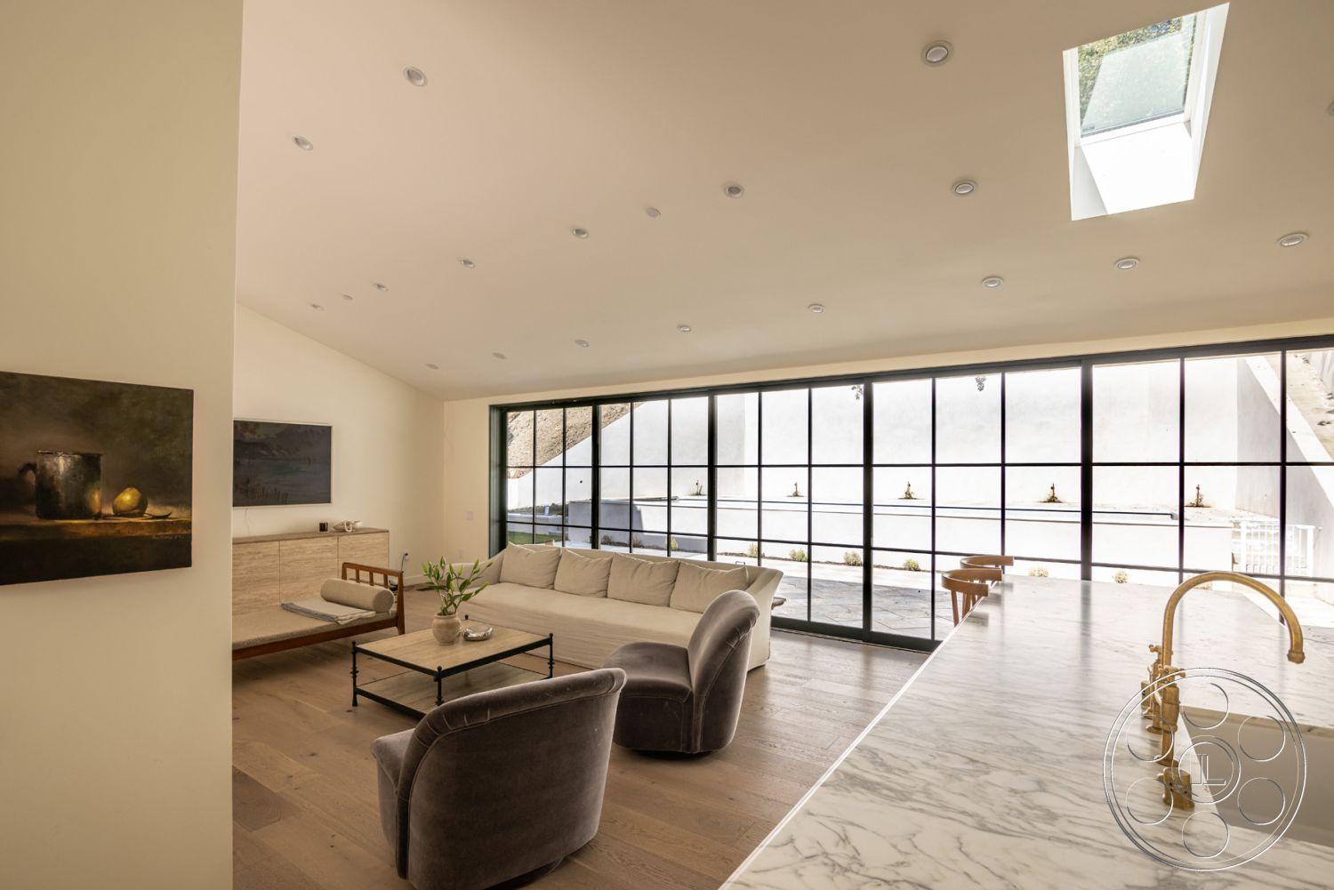 Modern Farmhouse 19 - interior recessed lighting, interior minimalist decor, interior hardwood living room floors, interior marble kitchen countertop, interior contemporary furniture, interior glass wall partitions, interior sliding glass doors, interior vaulted living room ceiling, interior exposed beam ceiling, interior sleek cabinetry, interior accent wall art, interior modern open layout, interior black frame windows, interior neutral wall paint, interior soft beige tones