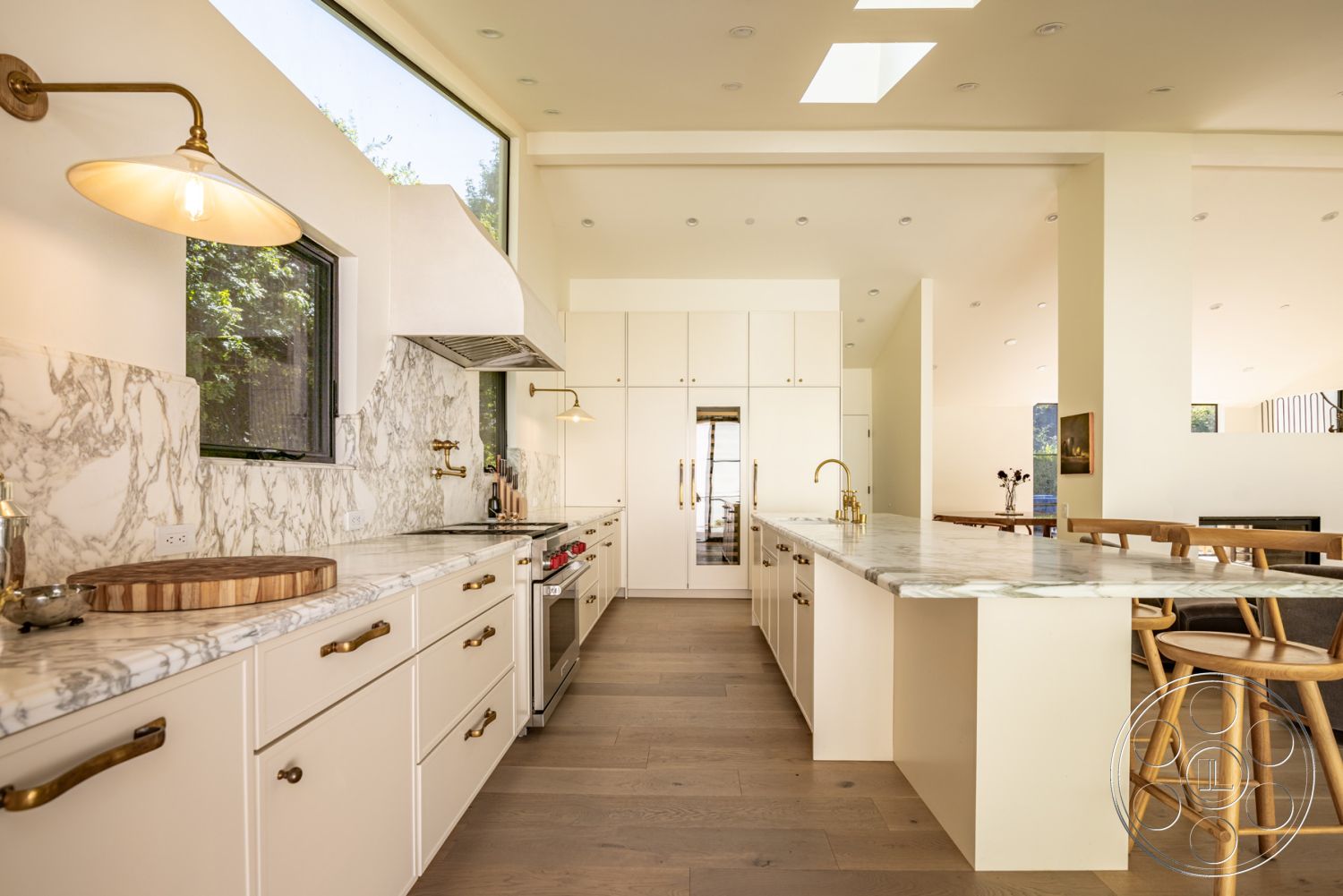 Modern Farmhouse 19 - natural light, stainless steel appliances, open concept layout, modern pendant lighting, floor-to-ceiling windows, interior kitchen, minimalist kitchen design, marble kitchen backsplash, coffered ceiling details, marble countertop island, hardwood flooring in kitchen, kitchen island with seating, white cabinetry with brass hardware, neutral interior colors, contemporary kitchen aesthetics