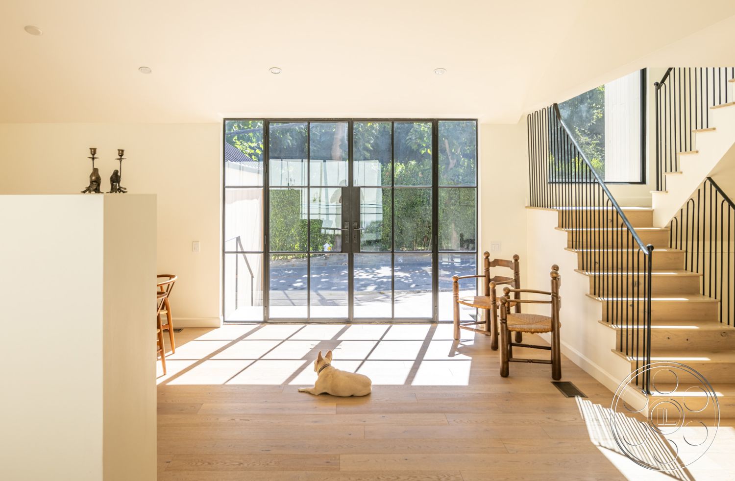 Modern Farmhouse 19 - large glass sliding doors, modern pendant lighting, floor-to-ceiling windows, urban garden view, exposed wood ceiling beams, contemporary living space, white painted walls, exterior patio area, minimalist design interior, black metal stair railings, natural lighting throughout, hardwood interior flooring, rectangular open layout, spacious entryway area, functional seating for living room, open concept home design