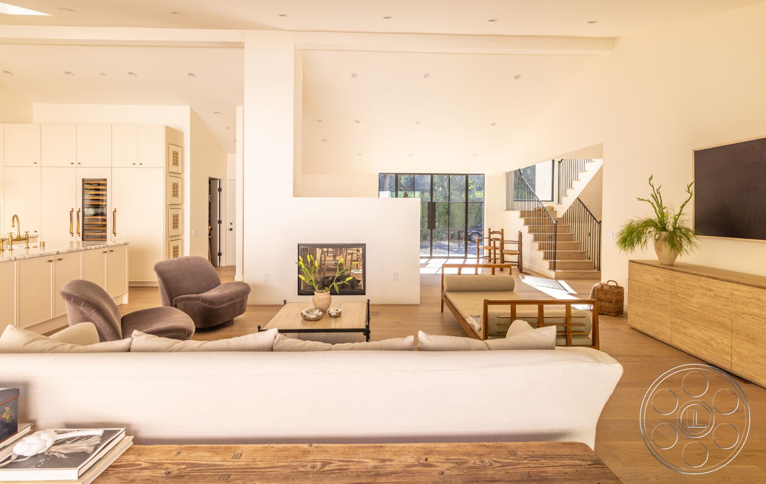 Modern Farmhouse 19 - neutral color palette, minimalist aesthetic, open floor plan, textured throw pillows, elegant light fixtures, contemporary coffee table, floating staircase, light-colored cabinetry, exposed wood ceiling beams, hardwood living room floors, white painted walls, potted indoor plants, glass wall partition, modern furniture design, natural light abundance, steel stair railings, linear fireplace surround, brass kitchen fixtures, sculptural art pieces