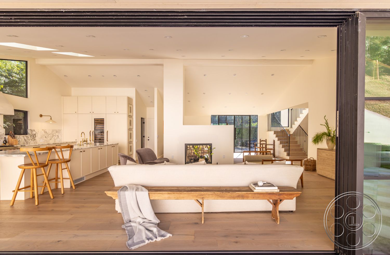 Modern Farmhouse 19 - interior neutral color palette, interior hardwood living room floors, interior marble kitchen countertop, interior floor-to-ceiling windows, interior open concept layout, interior cozy seating arrangement, interior white painted walls, interior natural light-filled space, interior contemporary furniture, interior minimalist dining area, interior stainless steel appliances, interior sloped ceiling, interior pendant lighting in kitchen, interior modern bar stool, interior wood beam accents, interior glass partition for stairway, interior gray area rug, interior modern staircase with steel railings, interior potted plants for decor, interior built-in kitchen cabinetry, interior architectural details with clean lines