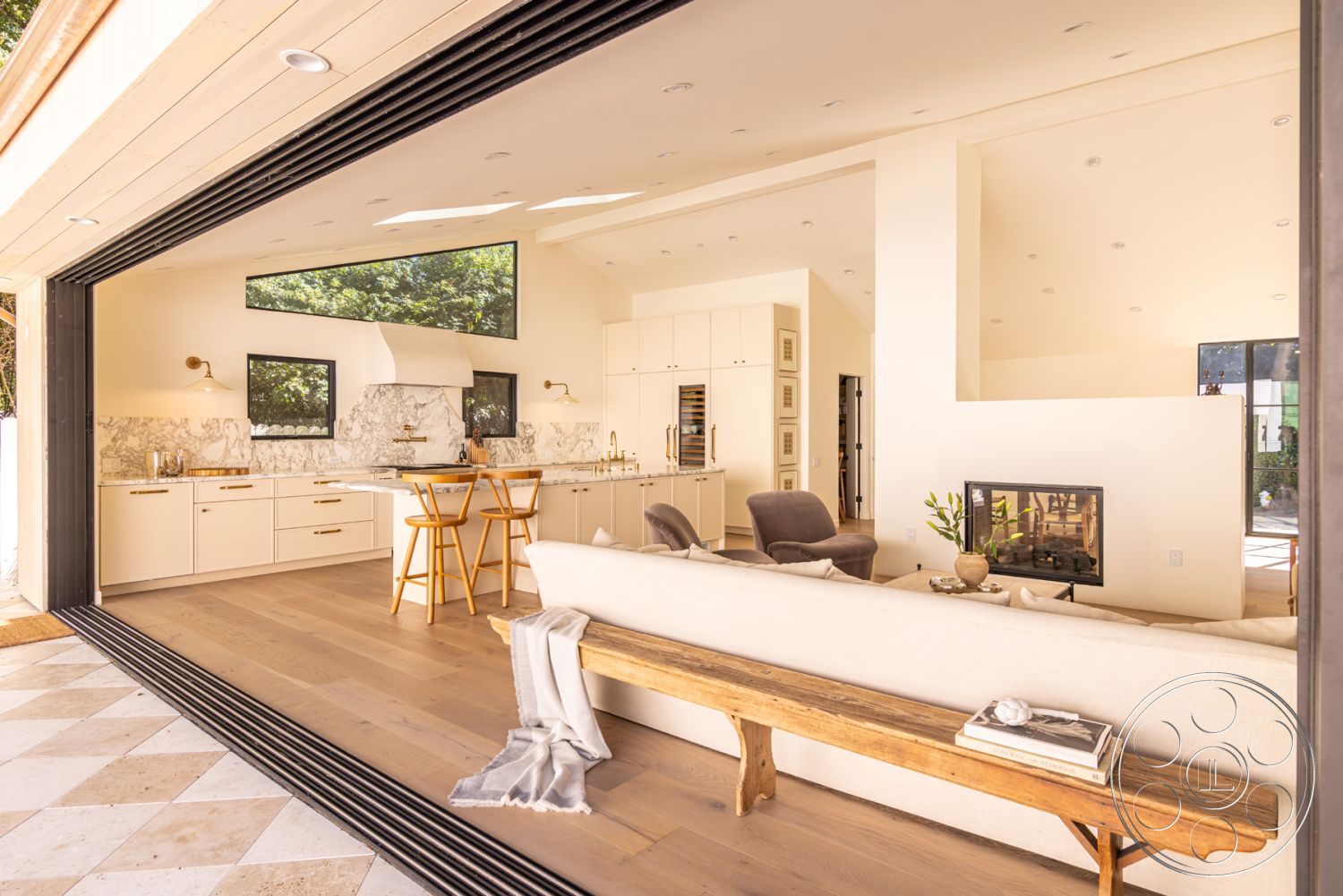 Modern Farmhouse 19 - interior vaulted ceiling, interior open-concept layout, interior neutral color palette, interior hardwood living room floors, interior marble kitchen backsplash, interior white painted walls, exterior landscaped garden view, interior contemporary design elements, exterior outdoor dining space, interior modern minimalist furniture, interior cozy sitting area, exterior folding glass doors, exterior modernist design, interior integrated stainless steel appliances, interior quartz countertop island, interior built-in cabinetry with brass hardware, interior geometric light fixtures, interior stone fireplace feature wall, interior panoramic window views, exterior contemporary patio