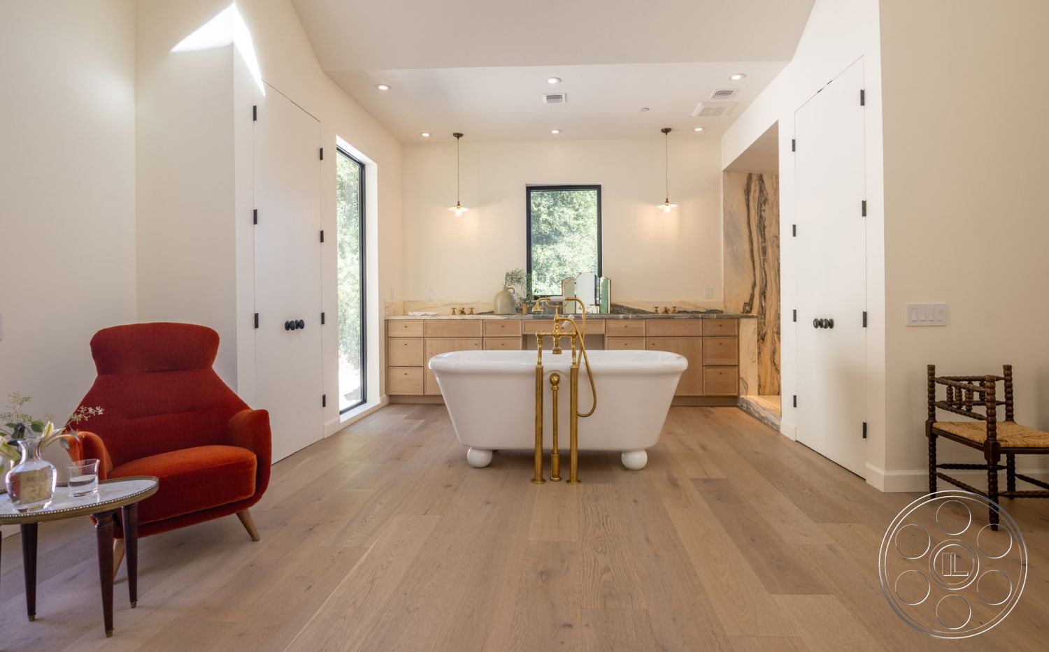 Modern Farmhouse 19 - neutral color palette, hardwood flooring, minimalist design, textured stone wall, open floor plan, freestanding bathtub, pendant lighting, double vanity, contemporary bathroom, cozy reading nook, gold faucet fixtures, subtle decorative elements, white painted walls, glass shower partition, natural light filled space, exposed wood elements, stylish bathroom accessories, modern vanity with natural wood finish, large black framed window, accent chair in red fabric