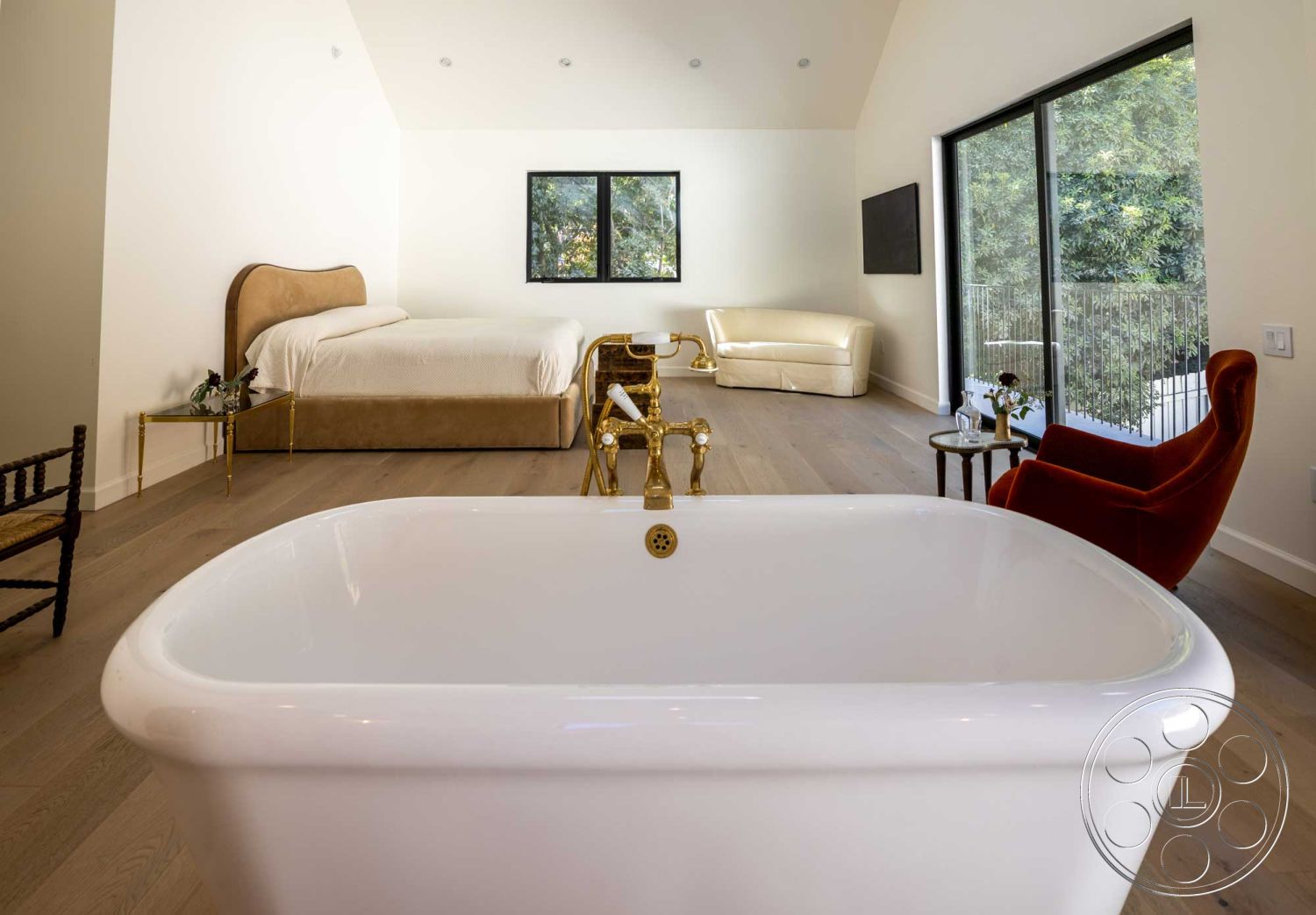 Modern Farmhouse 19 - minimalist design, open floor plan, modern light fixtures, textured wall finish, floor-to-ceiling windows, scenic garden view, hardwood bedroom floors, natural light ambiance, luxury seating area, contemporary accent chair, sleek furniture lines, bathtub with brass fixtures, king-sized bed with upholstered headboard, beige and white color palette, draped bedding