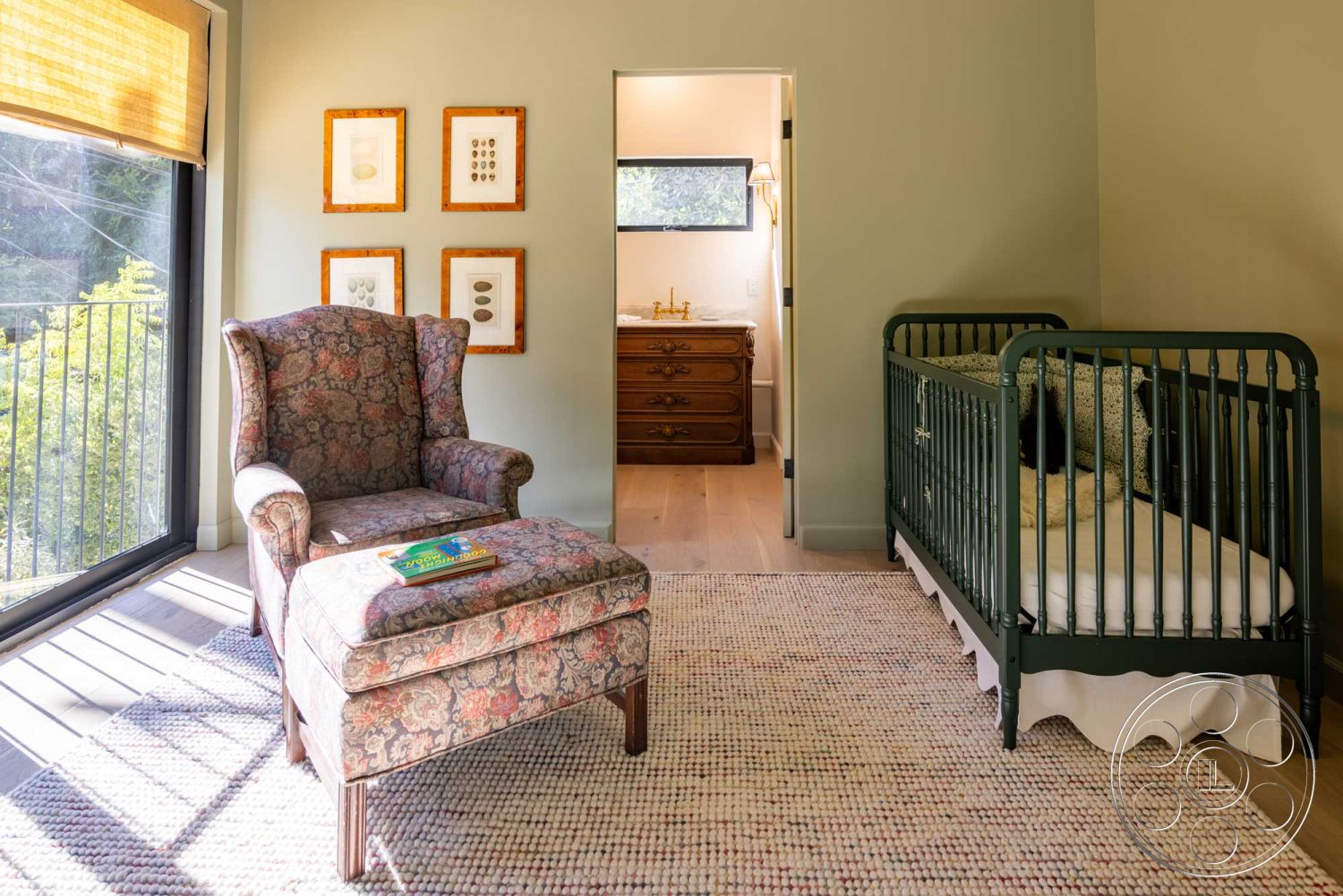 Modern Farmhouse 19 - hardwood flooring, family-friendly design, vintage armchair, large floor-to-ceiling windows, textured wall treatment, eco-friendly materials, open doorway, colorful area rug, contemporary interior, warm natural light, framed botanical prints, neutral painted walls, green metal crib, modern nursery, guidebook on the chair, classic wooden dresser, inviting room atmosphere, soft natural decor