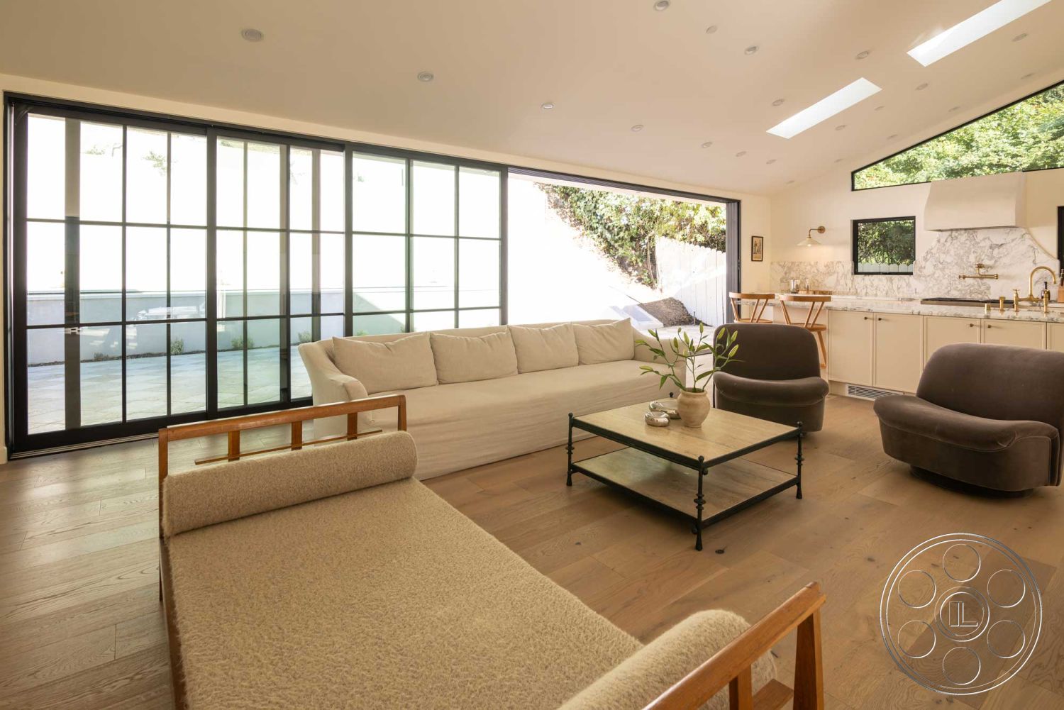 Modern Farmhouse 19 - neutral color palette, natural light, open floor plan, modern pendant lighting, glass sliding doors, floor-to-ceiling windows, textured wall finishes, contemporary seating area, rectangular coffee table, hardwood living room floors, marble kitchen countertops, minimalist interior design, built-in kitchen cabinets, exposed wood beam ceiling, urban hillside view, exterior deck