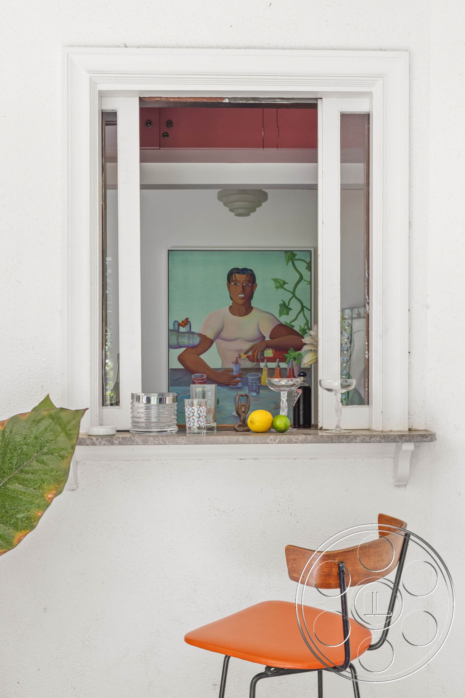 English 60 - natural light from window, contemporary interior design, flush ceiling light fixture, metal chair frame, minimalistic decor style, interior window with white trim, marble countertop overhang, exposed white stucco wall, artwork with human figure, wooden chair with orange seat cushion, stainless steel drinkware, glassware on countertop, citrus fruits as decorative elements, lush green indoor plant, small serving area in kitchen