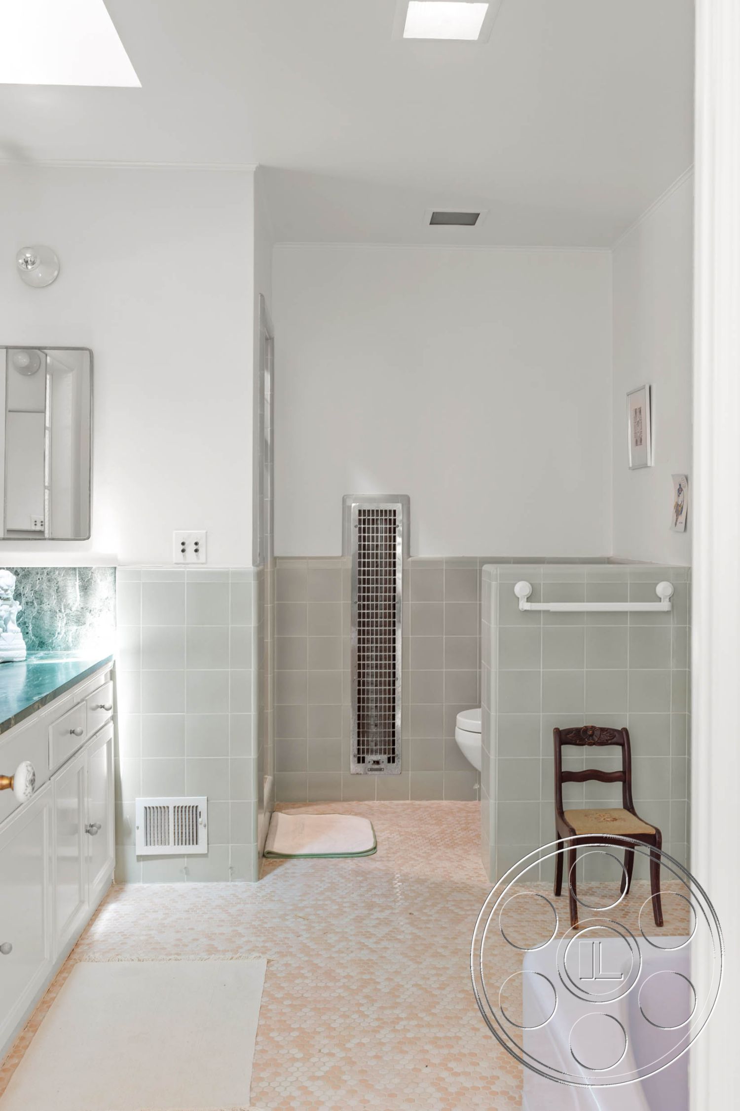 English 60 - minimalist decor, marble countertop, modern bathroom fixtures, interior bathroom, white painted walls, frameless glass shower partition, green ceramic tile walls, light-colored mosaic tile flooring, fixed skylights, compact wooden chair, overhead recessed lighting, built-in vanities