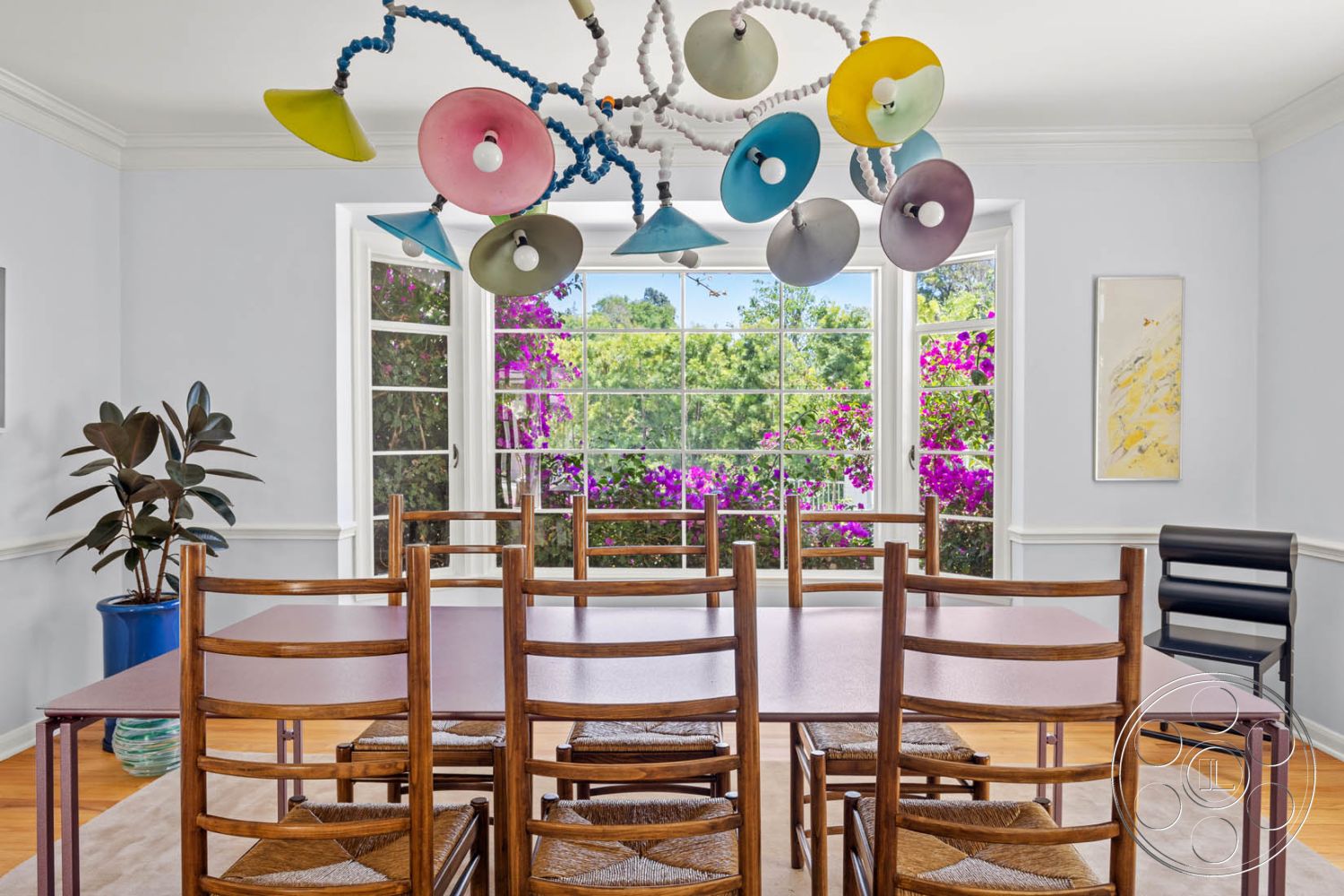 English 60 - wood dining table, modern art wall decor, hardwood floor, wooden dining chairs, interior dining room, large window with garden view, crown molding details, decorative potted plant, textured white walls, colorful pendant lighting, minimalist chair design