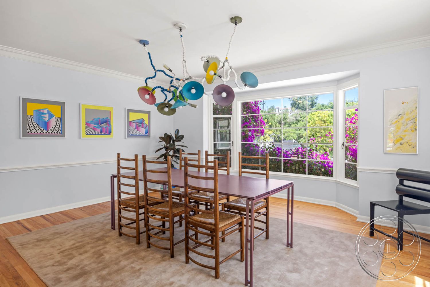 English 60 - plant decor, textured plaster walls, beige area rug, rectangular dining table, white painted walls, hardwood dining room floors, colorful abstract wall art, exposed wood crown molding details, modern pendant light chandelier, large bay window with garden view, eight-person dining arrangement